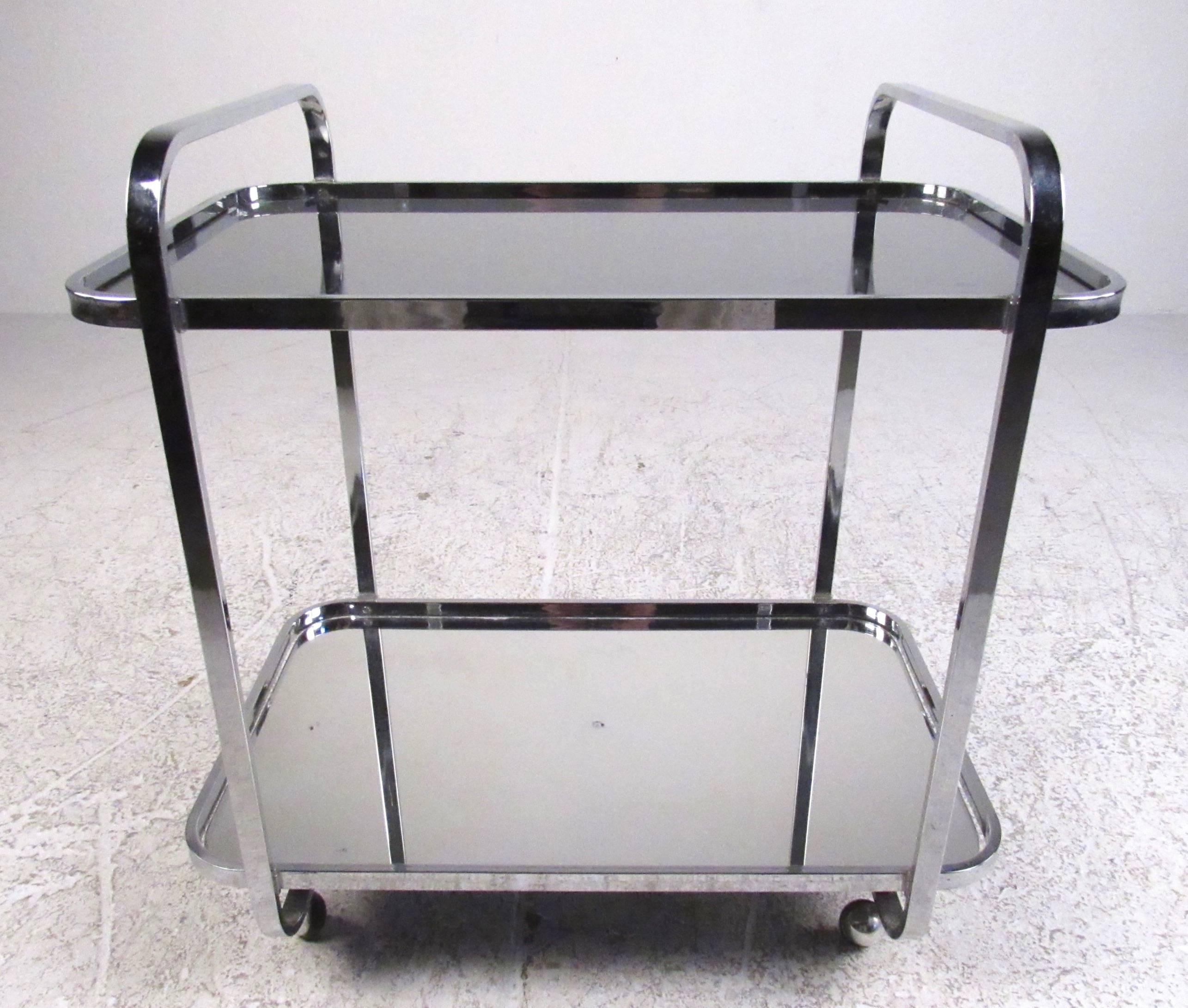 Offering plenty of room for storing glassware and bottle, this Mid-Century chrome and glass service cart makes a stylish and versatile addition to home or business. Top shelf is made of smoked glass, bottom has a mirrored finish. An impressive