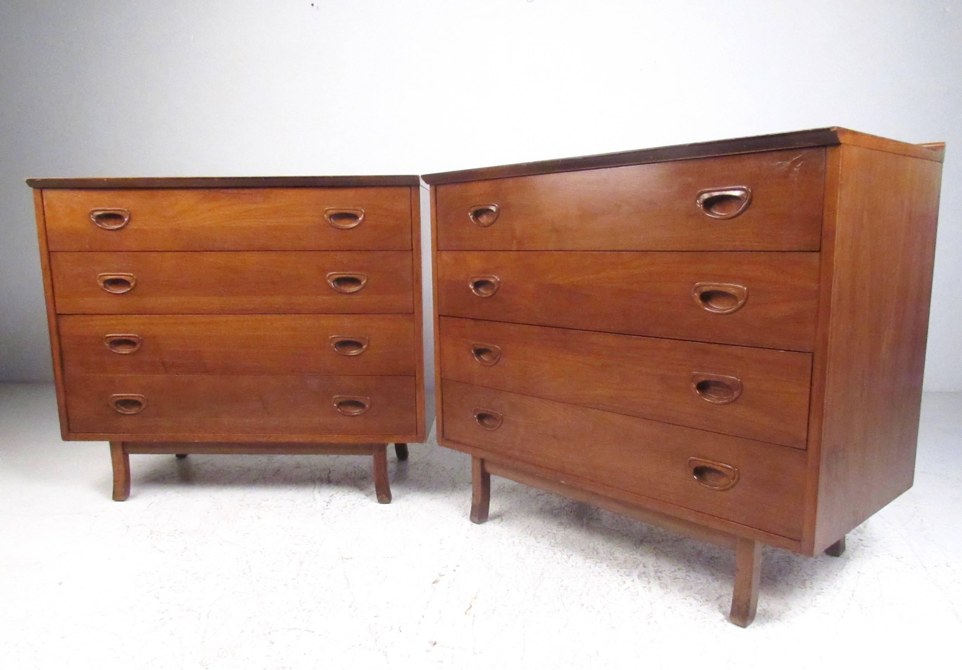 This stylish pair of American walnut dressers feature four spacious drawers, carved pulls, and raised rear edges. Slight taper to the sculpted hardwood legs rounds out the Mid-Century Modern appeal of this vintage matching pair. Please confirm item