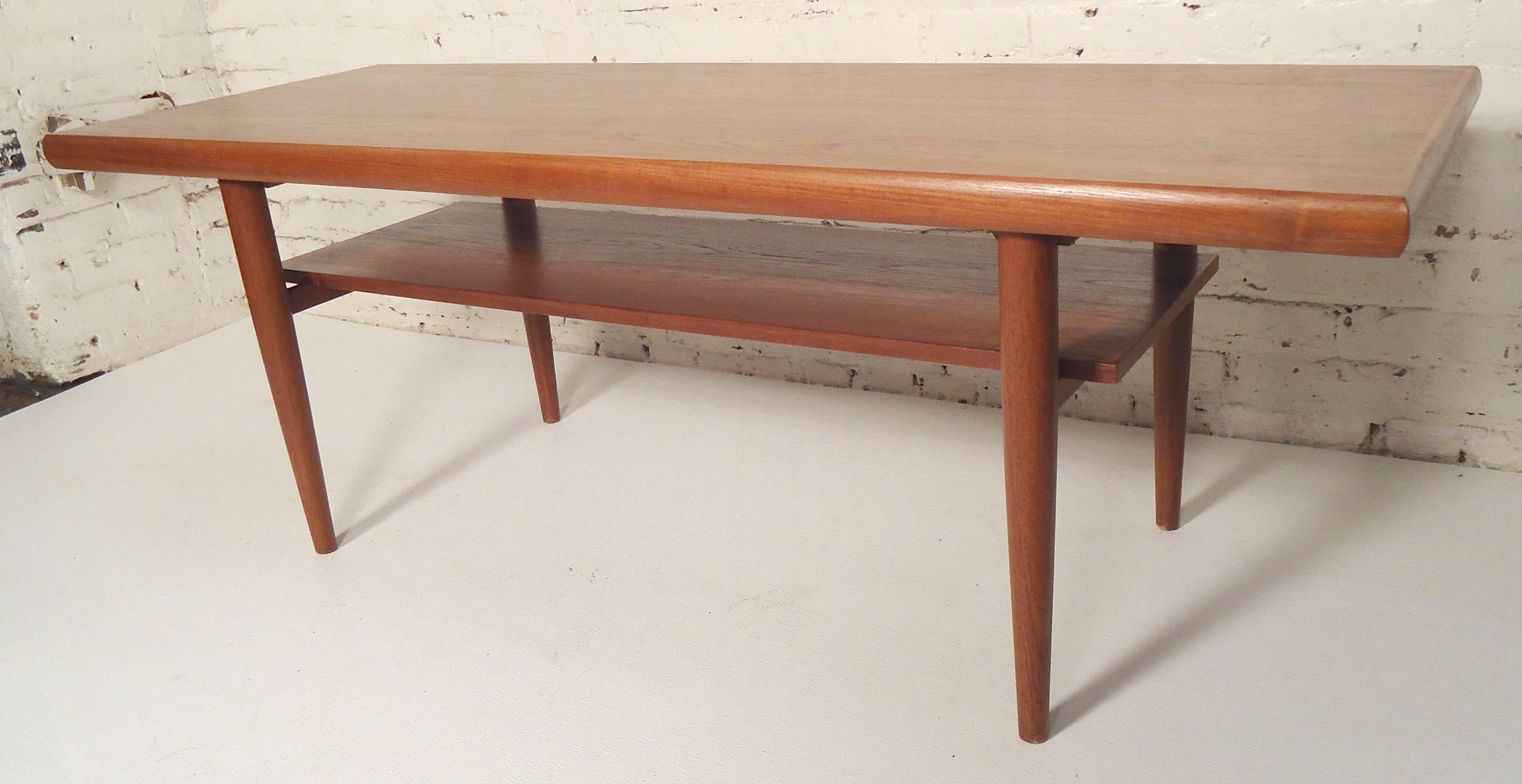 Attractive Mid-Century table with bottom shelf. Rounded sides and tapered legs.

(Please confirm item location - NY or NJ - with dealer).
 