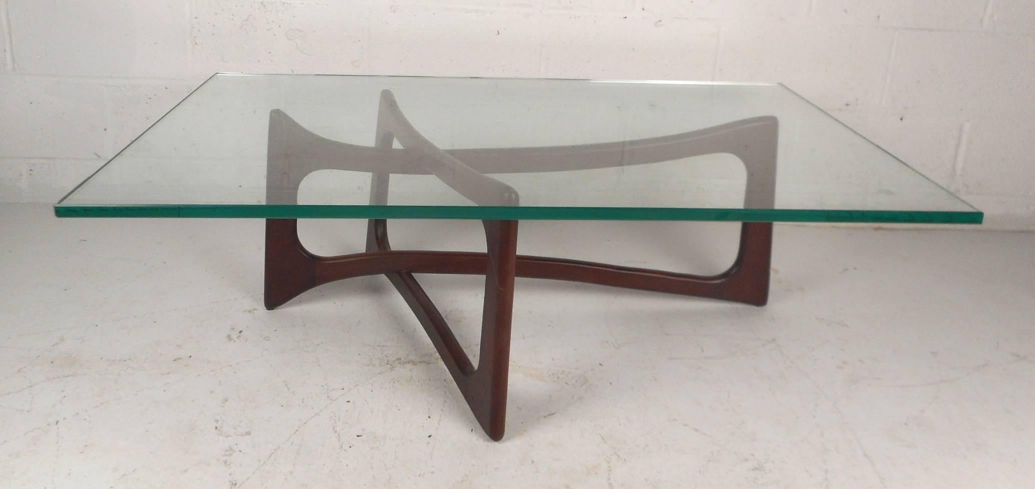 This Classic vintage modern coffee table by Adrian Pearsall for Craft Associates features an unusual sculpted base with an incredibly thick glass top. Unique solid dark walnut base with sleek curves and bends ensuring plenty of sturdiness without