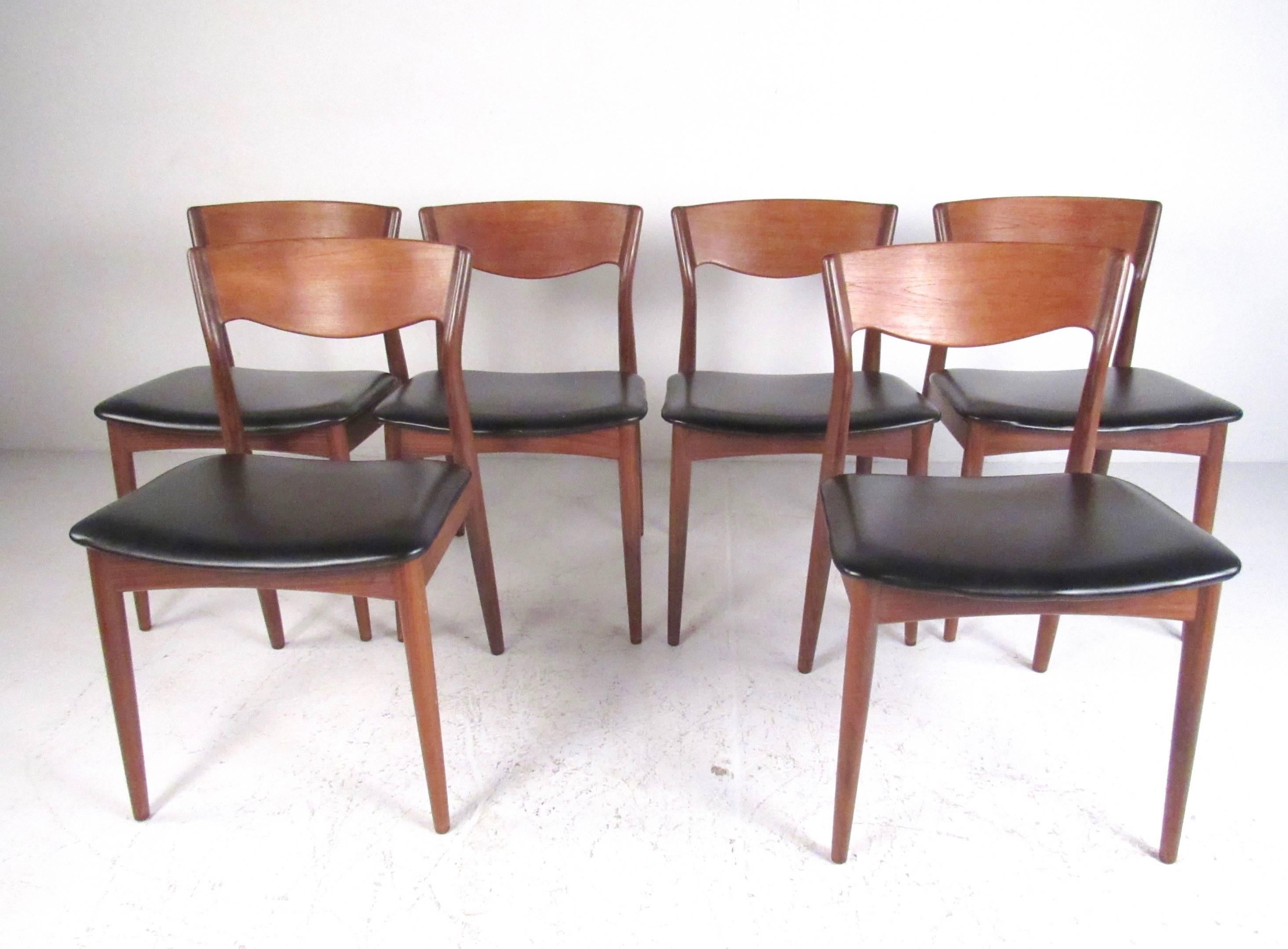 This stylish Danish modern dining set features six sculpted seats by Arne Hovmand Olsen for Mogens Kold Mobelfabrik are paired with this teak dining table. Comfortable sculpted teak dining chairs feature padded seats and attractive Mid-Century