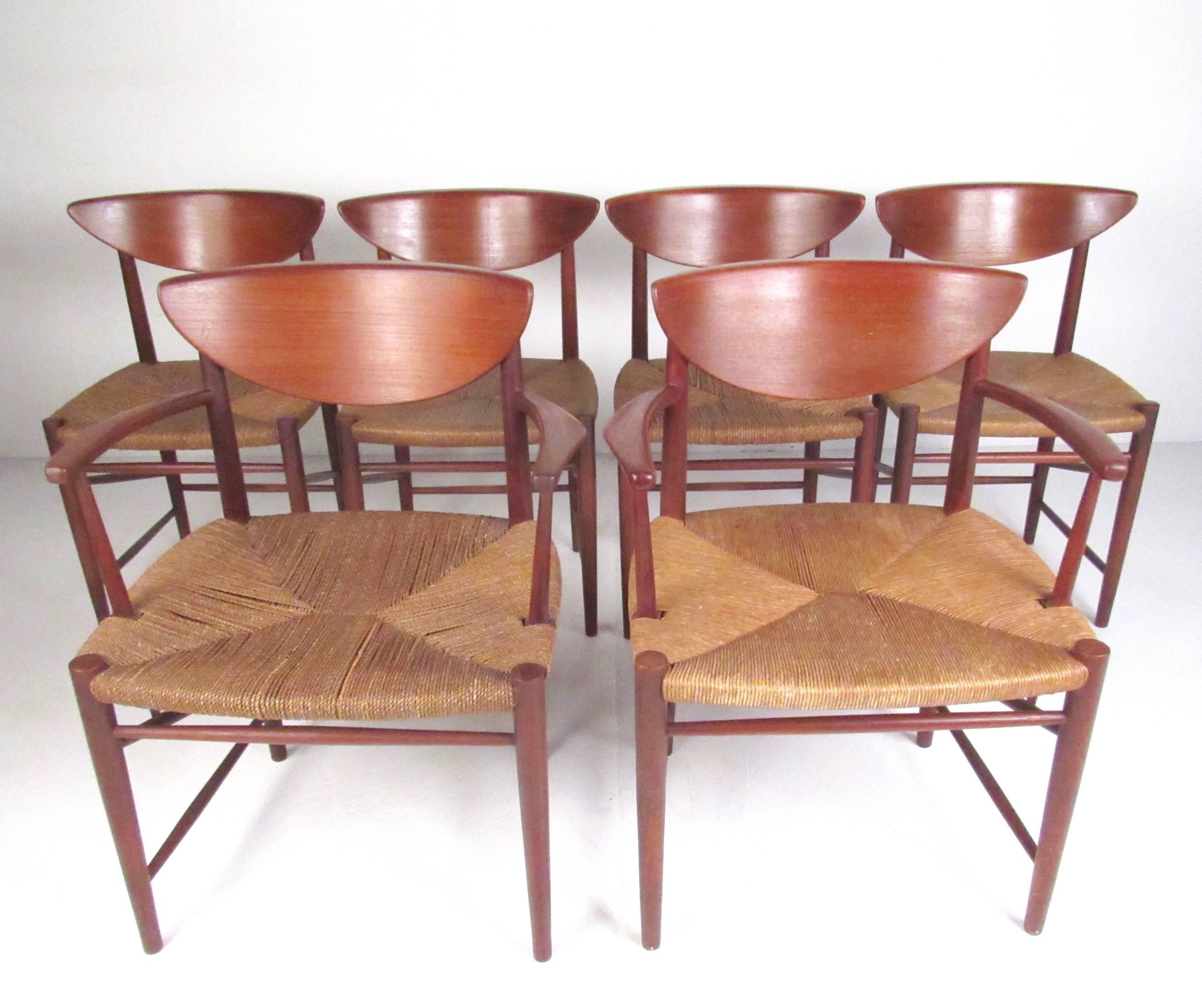 This gorgeous set of Mid-Century Modern teak dining chairs feature sculpted teak frames and iconic woven rush seats. Designed by Peter Hvidt for Soborg Mobelfabrik, this stylish set of six chairs boast a rich teak finish and comfortable design.
