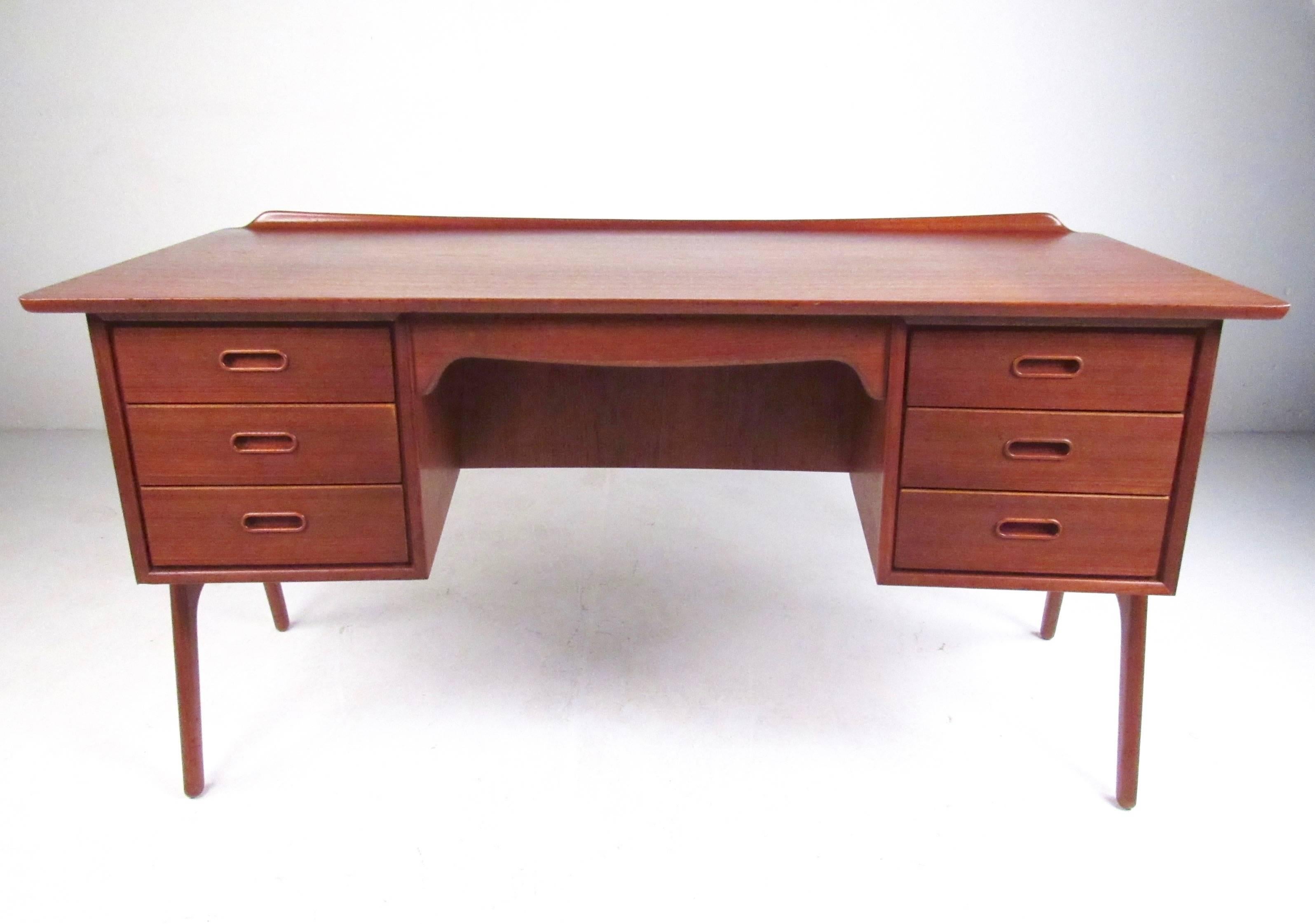This stunning teak desk by Svend Madsen for Sigurd Hansen makes a beautiful desk for any office, showcasing the finest points of midcentury Scandinavian design. Sculpted legs, raised back edge, and open shelf back make this an impressive writing