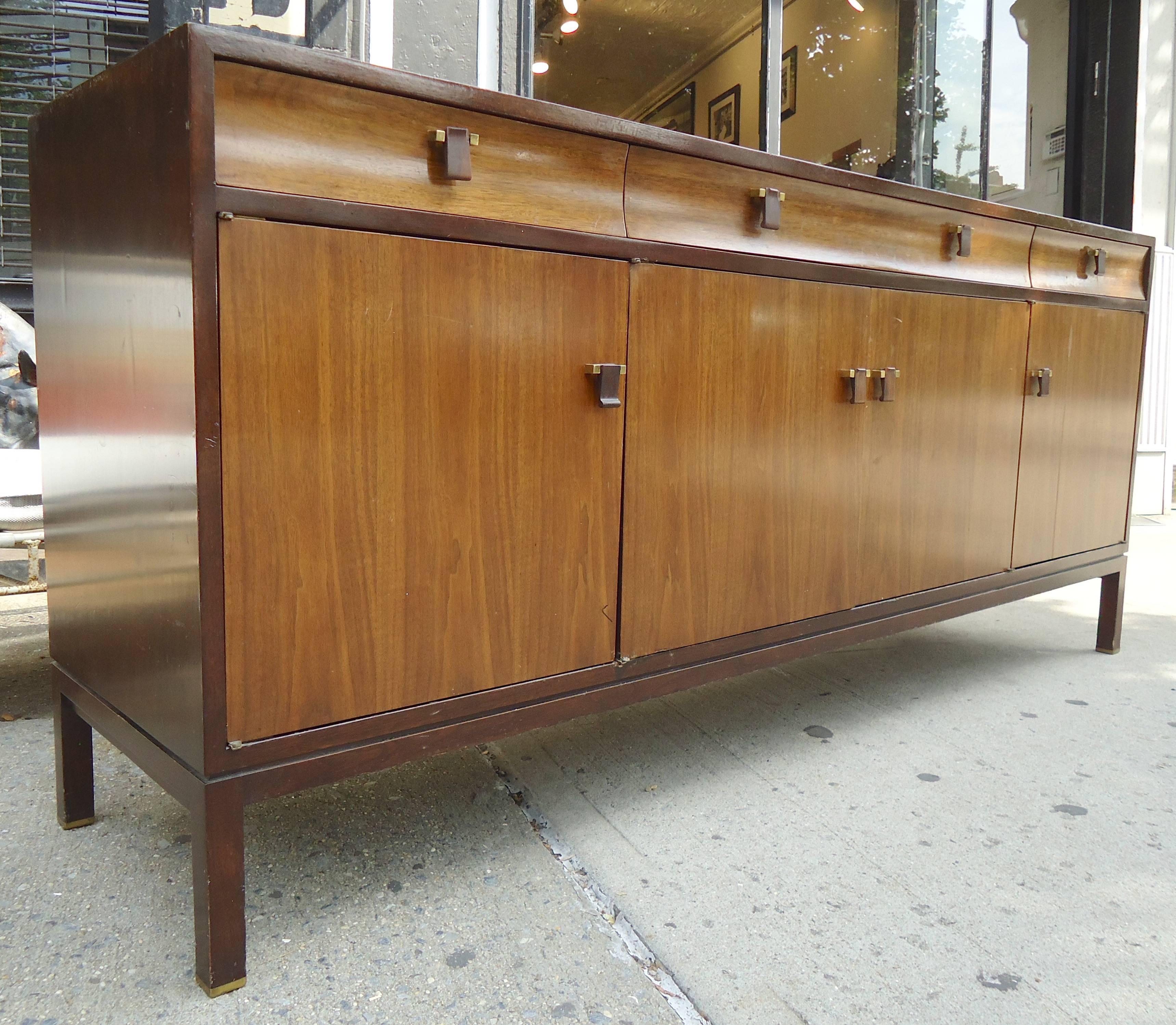 Mid-Century Modern two-tone sideboard by Dunbar. Featuring dark espresso finish frame, walnut grain an rosewood handles, accented by brass hardware.

(Please confirm item location - NY or NJ - with dealer).
  
