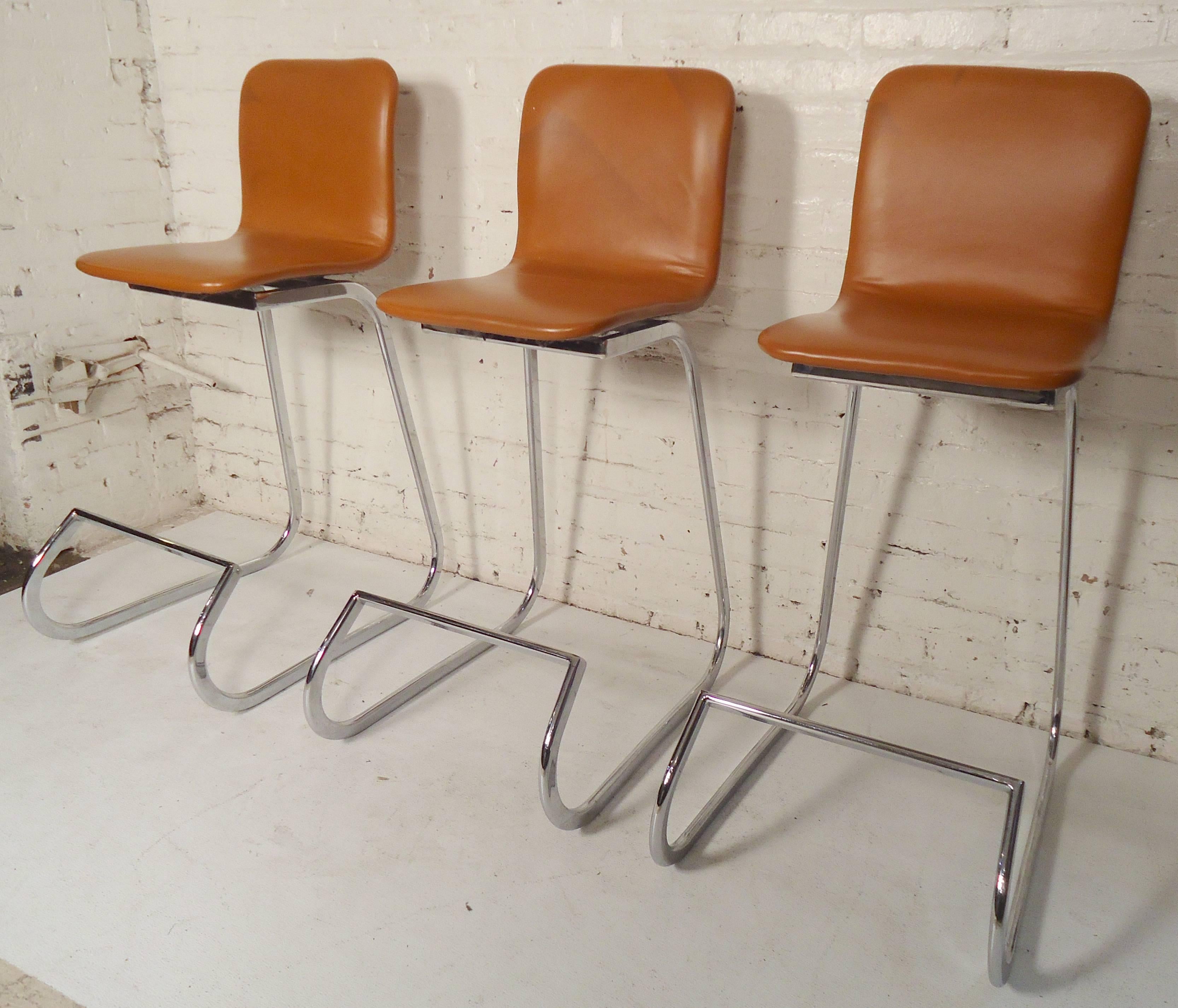 Set of three (six available) polished chrome stools with light brown leatherette material. Very soft and comfortable.

(Please confirm item location NY or NJ with dealer).
     