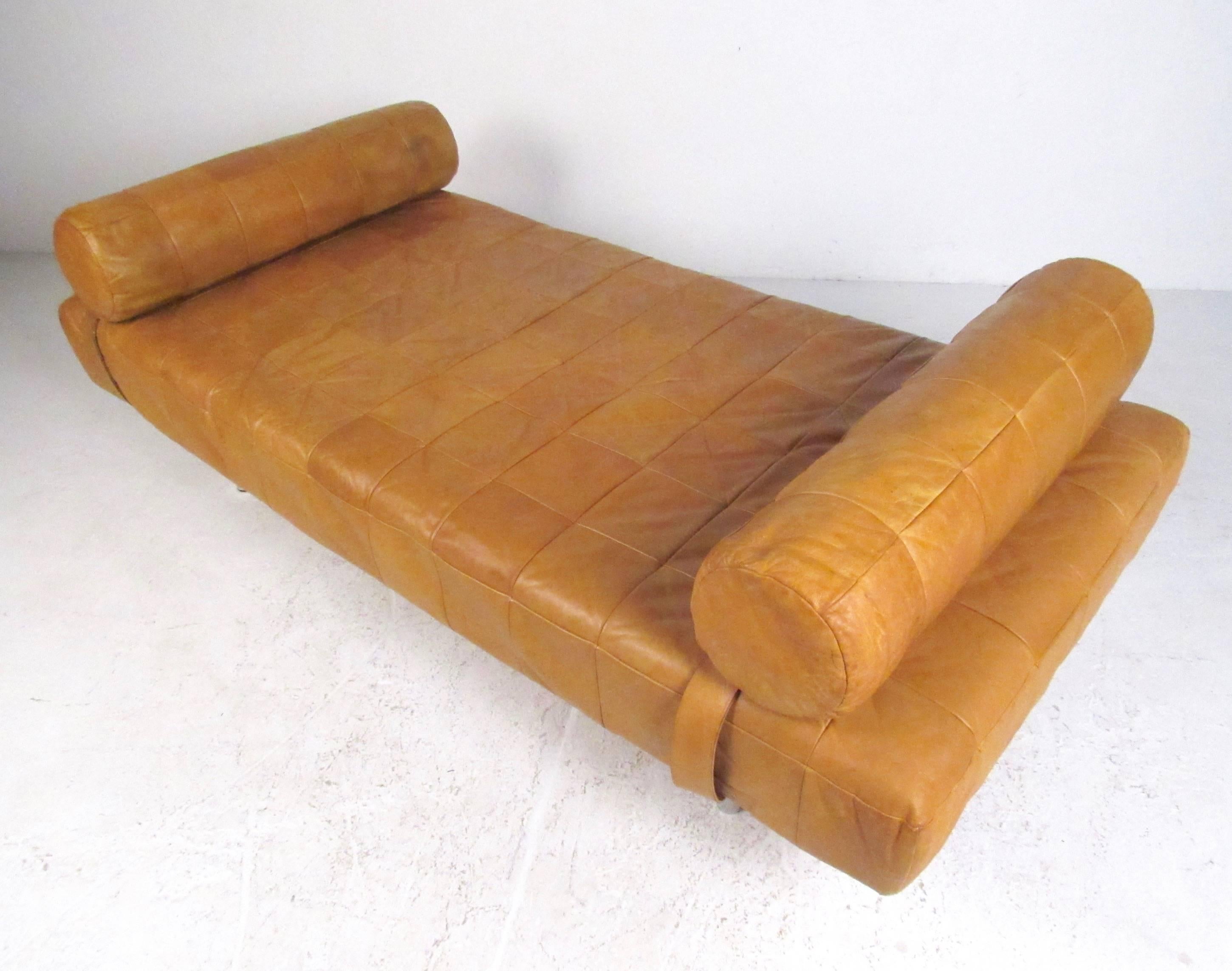 This stylish vintage leather daybed by Stendig features patchwork upholstery and two matching bolsters. Tubular chrome legs add to the Mid-Century Modern appeal of this comfortable and impressive daybed, perfect addition to home or office. Please