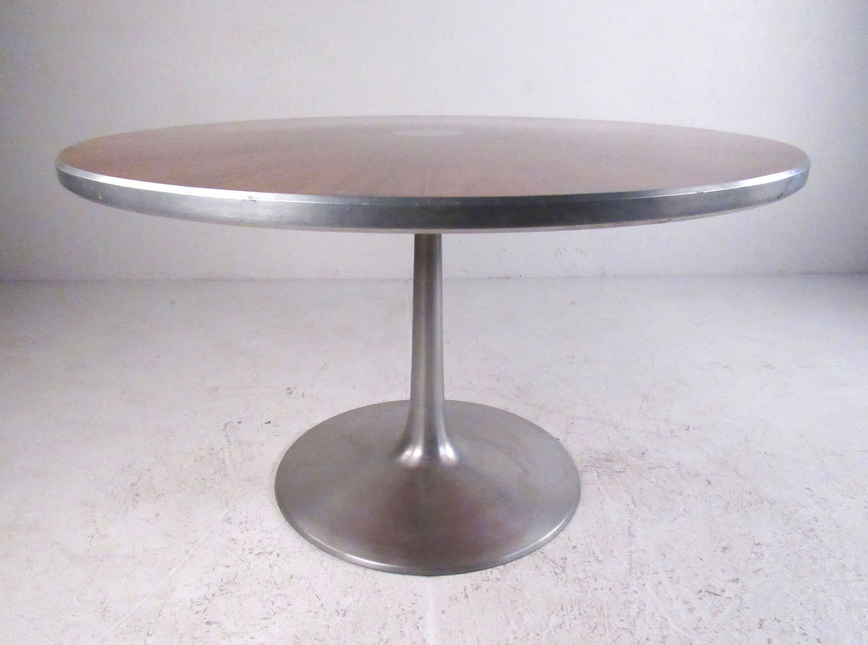 Esta impresionante mesa circular con pedestal presenta un acabado de mediados de siglo en aluminio y palisandro. Diseñada por Poul Cadovius para France and Son, el atractivo moderno escandinavo de este centro de mesa es un impresionante complemento