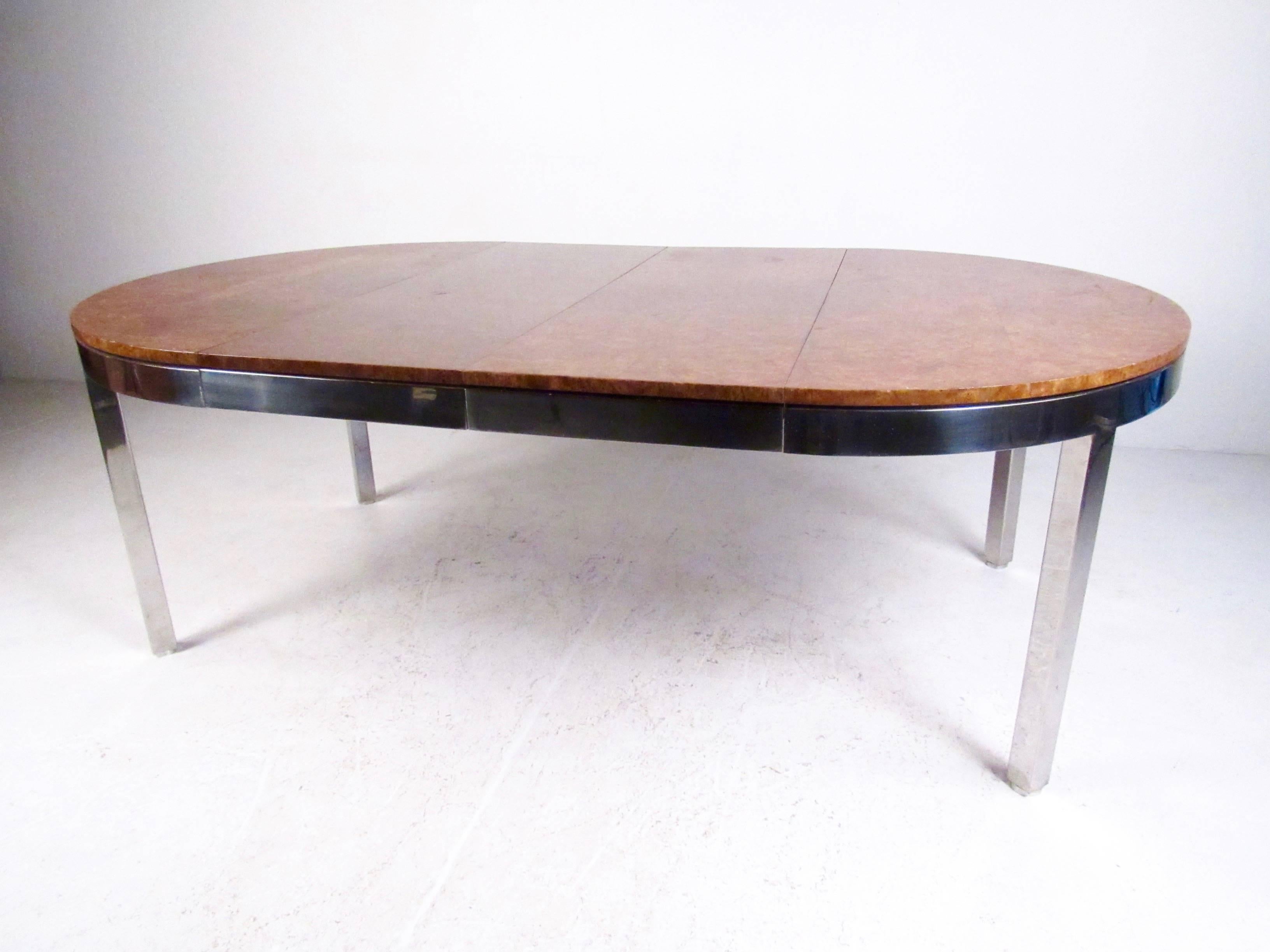 This stunning chrome frame dining table features heavy quality construction with rich vintage burl finish. Designed in the midcentury style of Milo Baughman, this circular dining table accommodates two leaves and expands from 48 inches in diameter