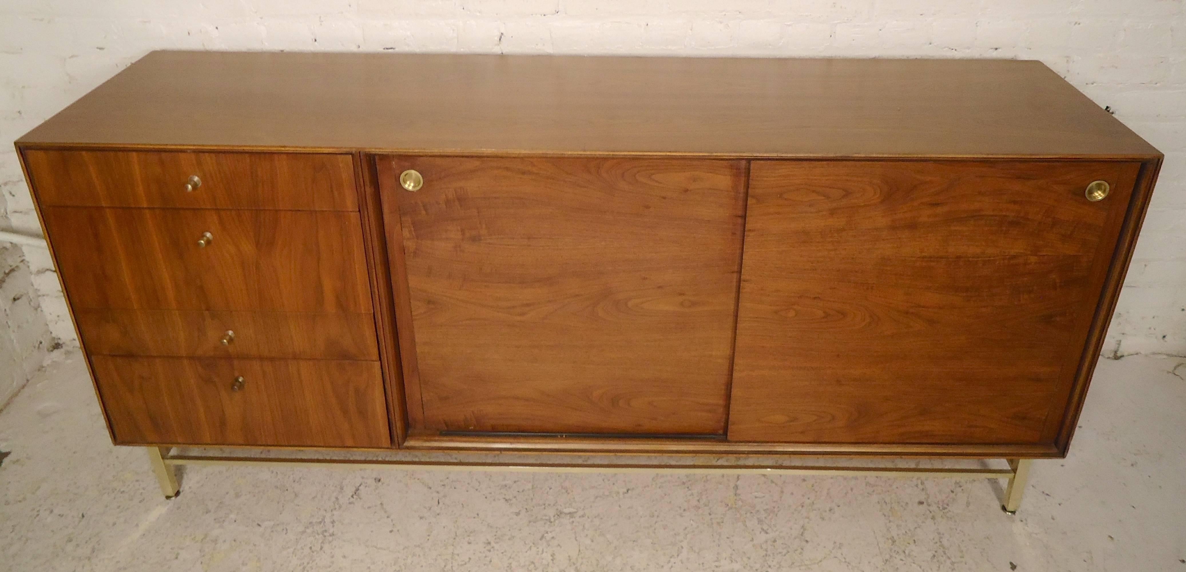 Beautiful vintage sliding door cabinet with brass trim and accents. Twelve total drawers make for a great bedroom dresser.

(Please confirm item location, NY or NJ, with dealer).
 