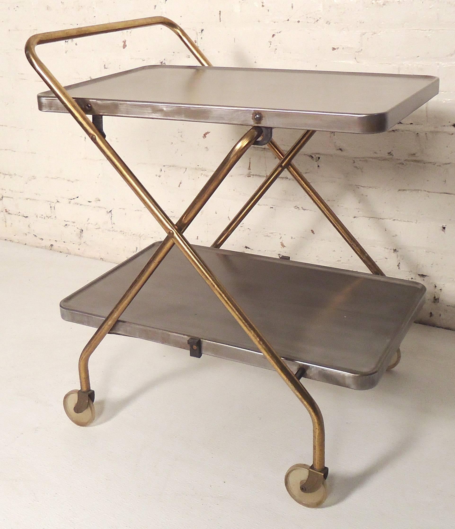 Vintage hospital cart has been restored to make a modern bar cart. Stripped metal trays with brass frame and large casters.

(Please confirm item location - NY or NJ - with dealer).
    