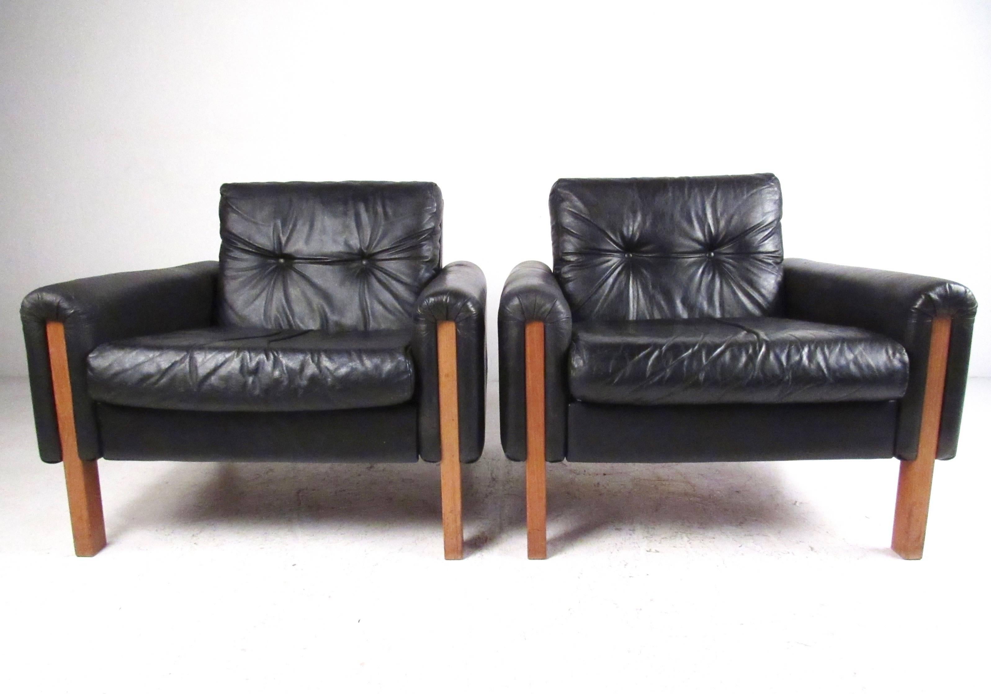 This beautiful pair of vintage armchairs makes for a stylish and comfortable addition to any seating arrangement. Tufted black leather upholstery is nicely complimented by hardwood legs and unique mid-century design by Stendig Inc. Please confirm