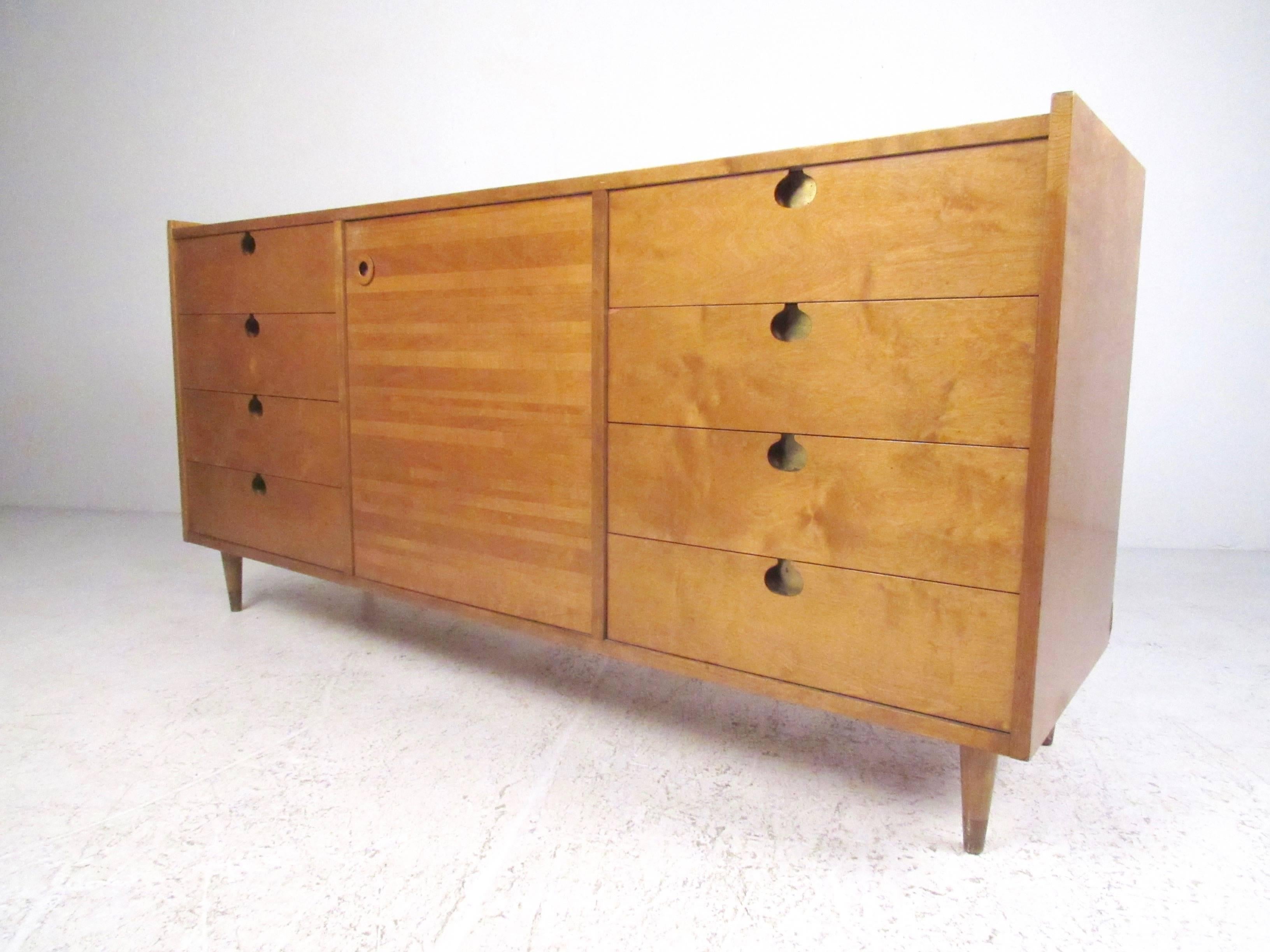 This stylish Scandinavian Modern dresser by Edmond J. Spence features spacious side-by-side storage including drawer and shelf space. Quality vintage construction and unique mid-century design make this an impressive addition to any bedroom. Tapered