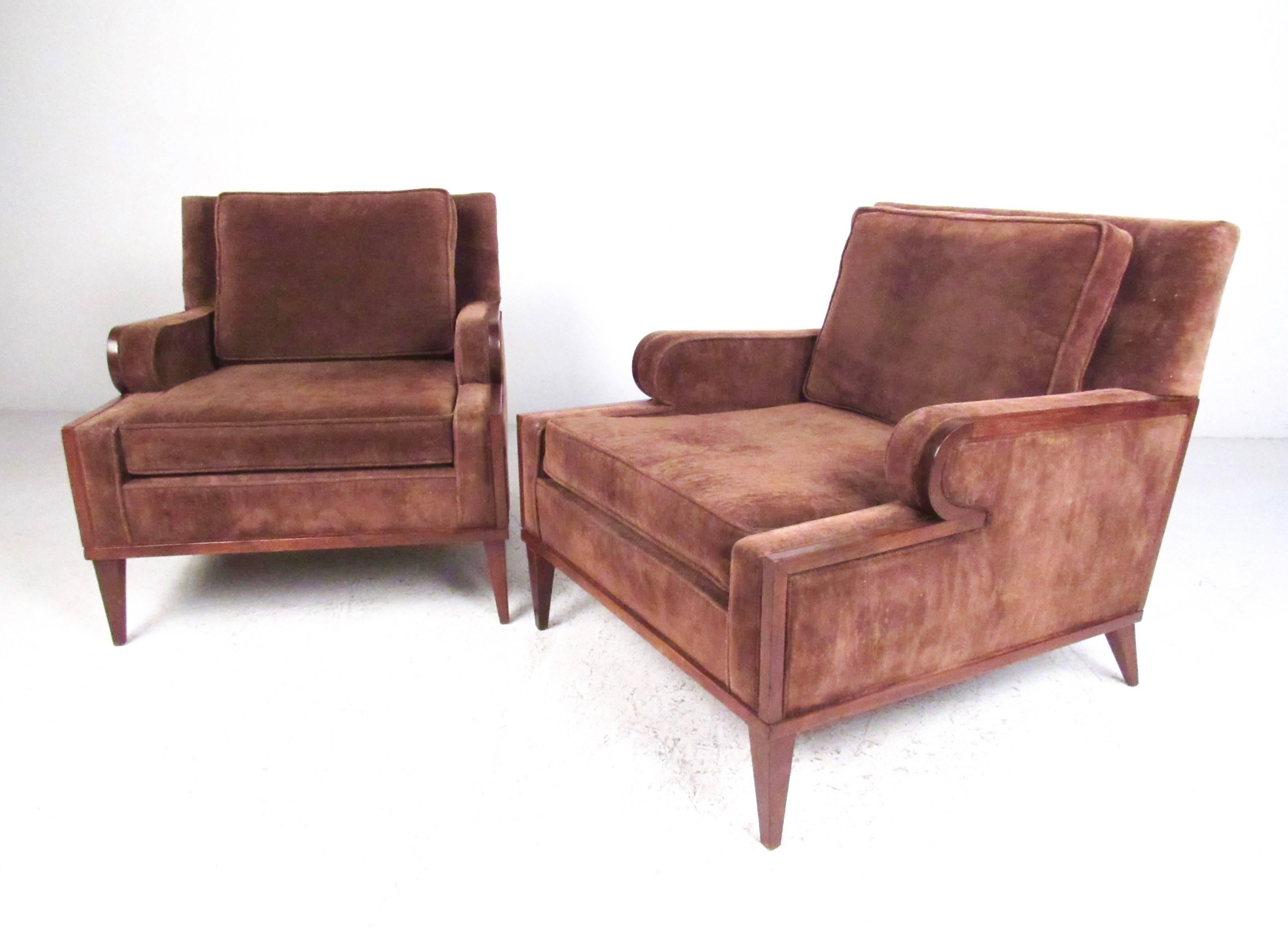 This stylish pair of vintage modern club chairs feature low profile armrests, tapered walnut frames, and wife, plush, upholstered seats. This beautiful matched set of lounge chairs make for an impressive addition to home or business seating area.