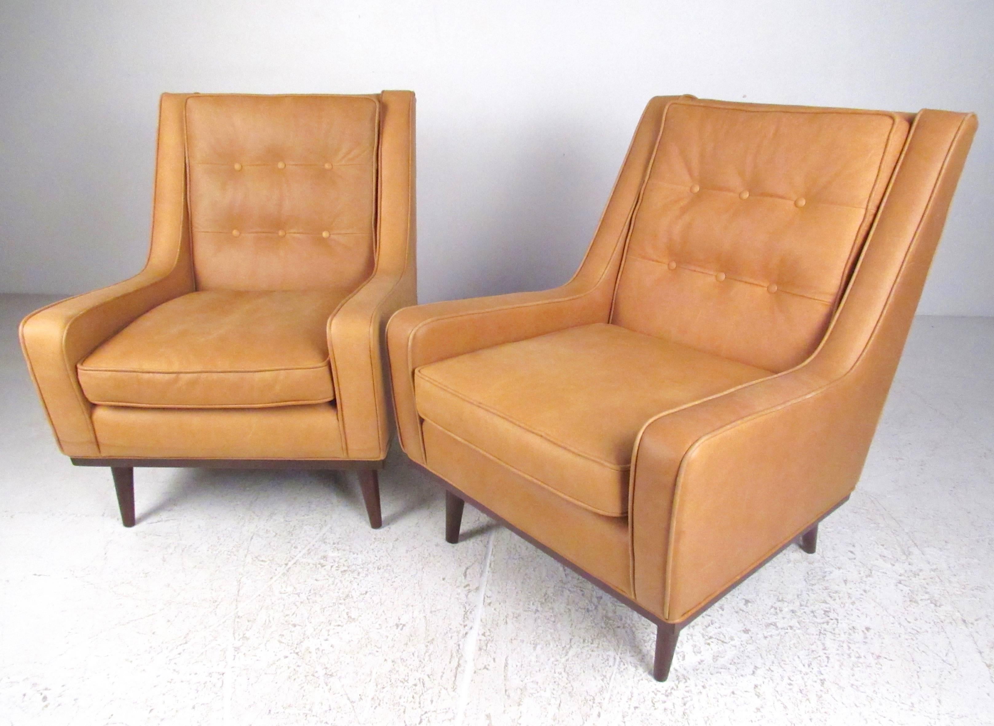 This beautiful pair of stylish leather club chair feature modern tapered legs, sleek low profile armrests, and spacious comfortable seats. Please confirm item location (NY or NJ).