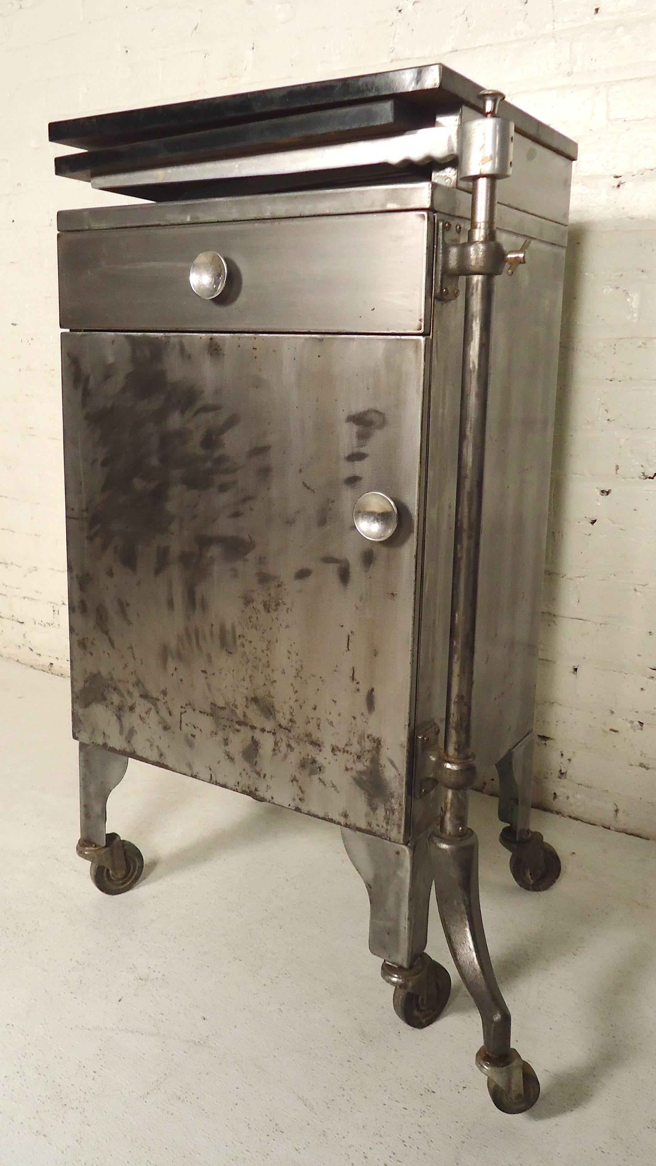 Restored medical cabinet with extending tabletop. Cabinet and drawer storage, extending tabletop that also can be lifted to be all level.
Measures: Top shelf is 20