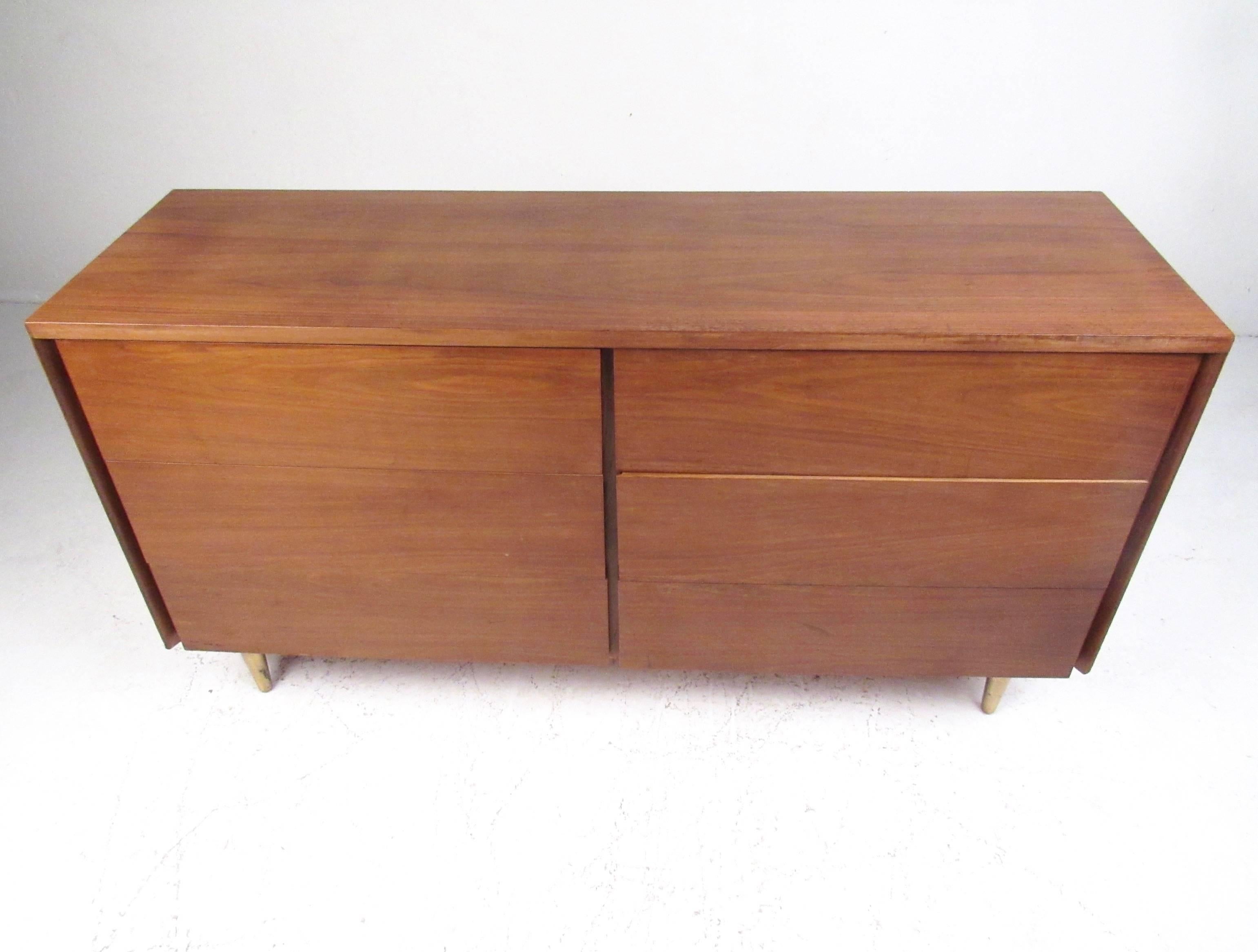 This stylish vintage modern dresser features six spacious drawers with rich hardwood finish and tapered brass legs. Manufactured by John Stuart, this midcentury bedroom dresser makes as striking addition in any setting. Please confirm item location