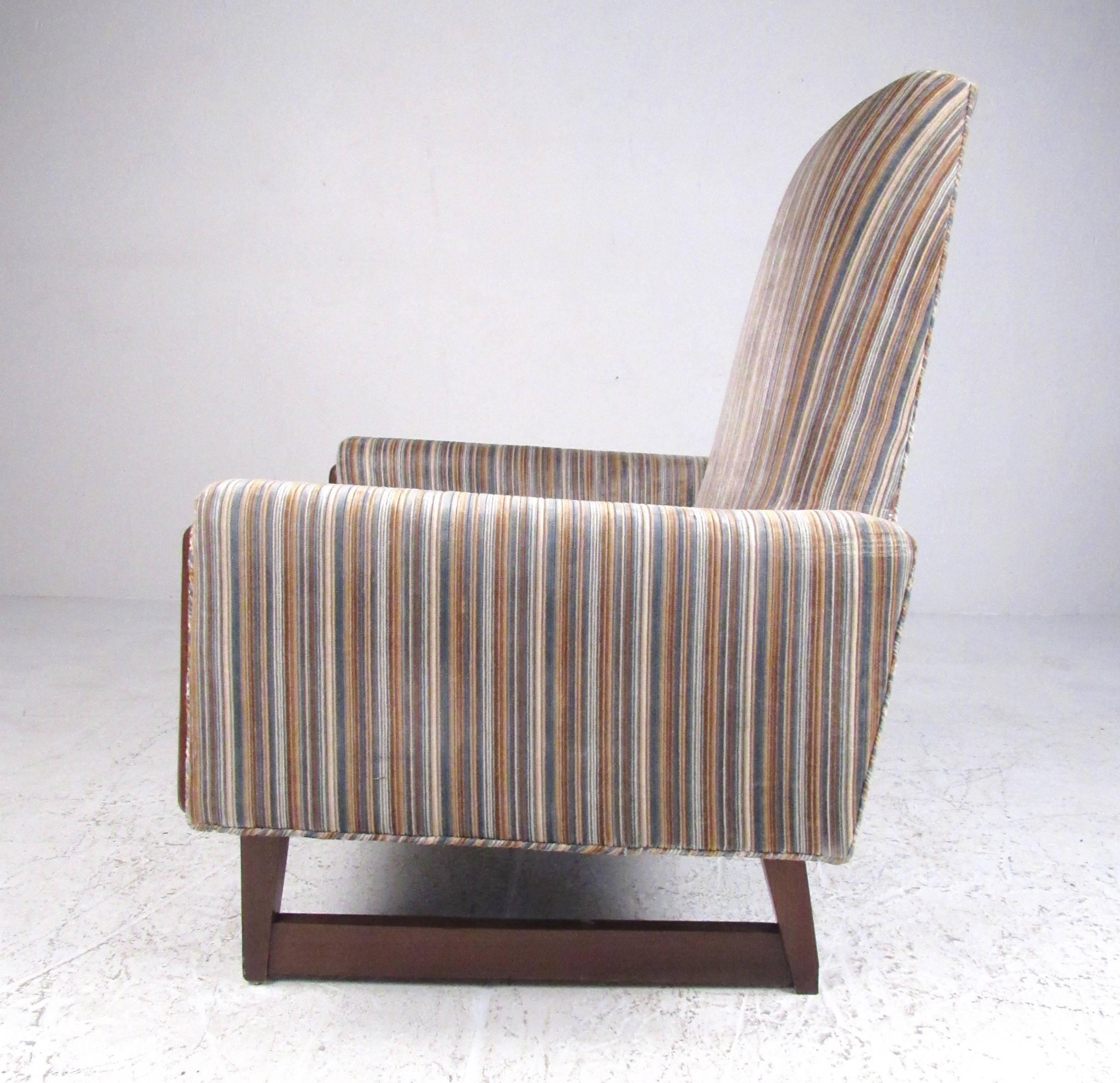 Ce fauteuil de salon vintage unique présente un haut dossier sculpté, une garniture en noyer unique et un tissu rayé vintage. Les pieds en forme de traîneau ajoutent à l'attrait moderne du milieu du siècle de cette chaise de style Adrian Pearsall.