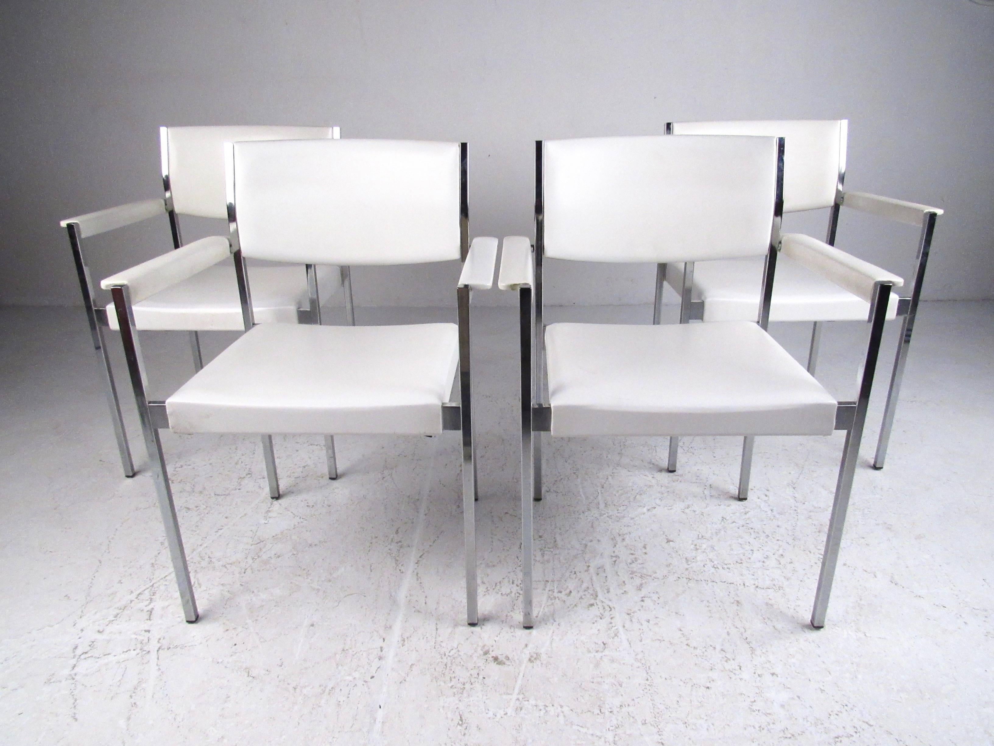 This set of four stylish and comfortable dining chairs by John Stuart Inc feature spacious vinyl seats, upholstered armrests, and sturdy chrome frame construction. Original makers mark affixed on this Mid-Century Modern set, please confirm item