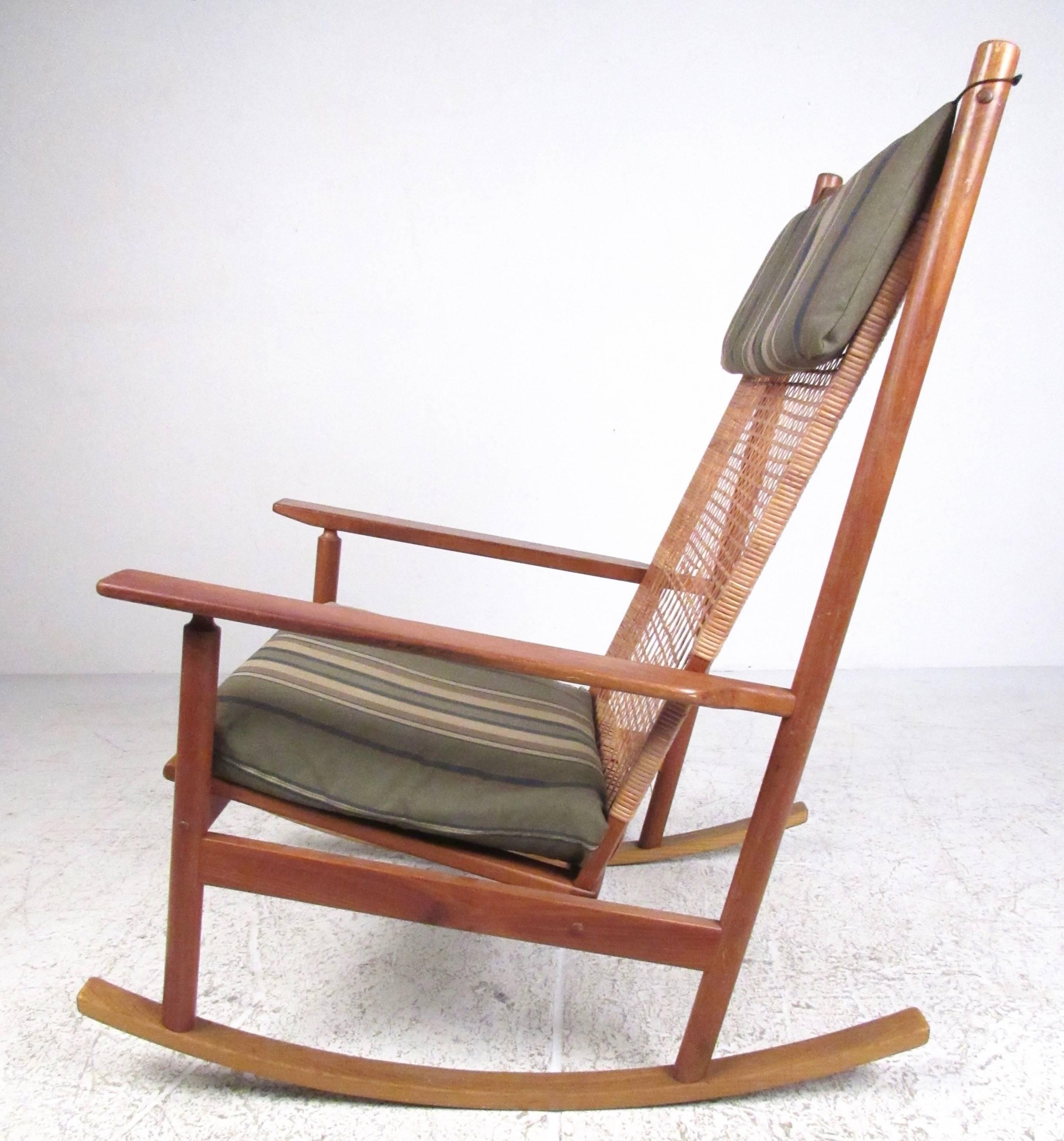 This impressive vintage modern rocking chair features high back teak frame with vintage cane webbing. Added cushion for headrest and seat, iconic Scandinavian Modern design by Hans Olsen for Juul Kristensen. Please confirm item location (NY or NJ).