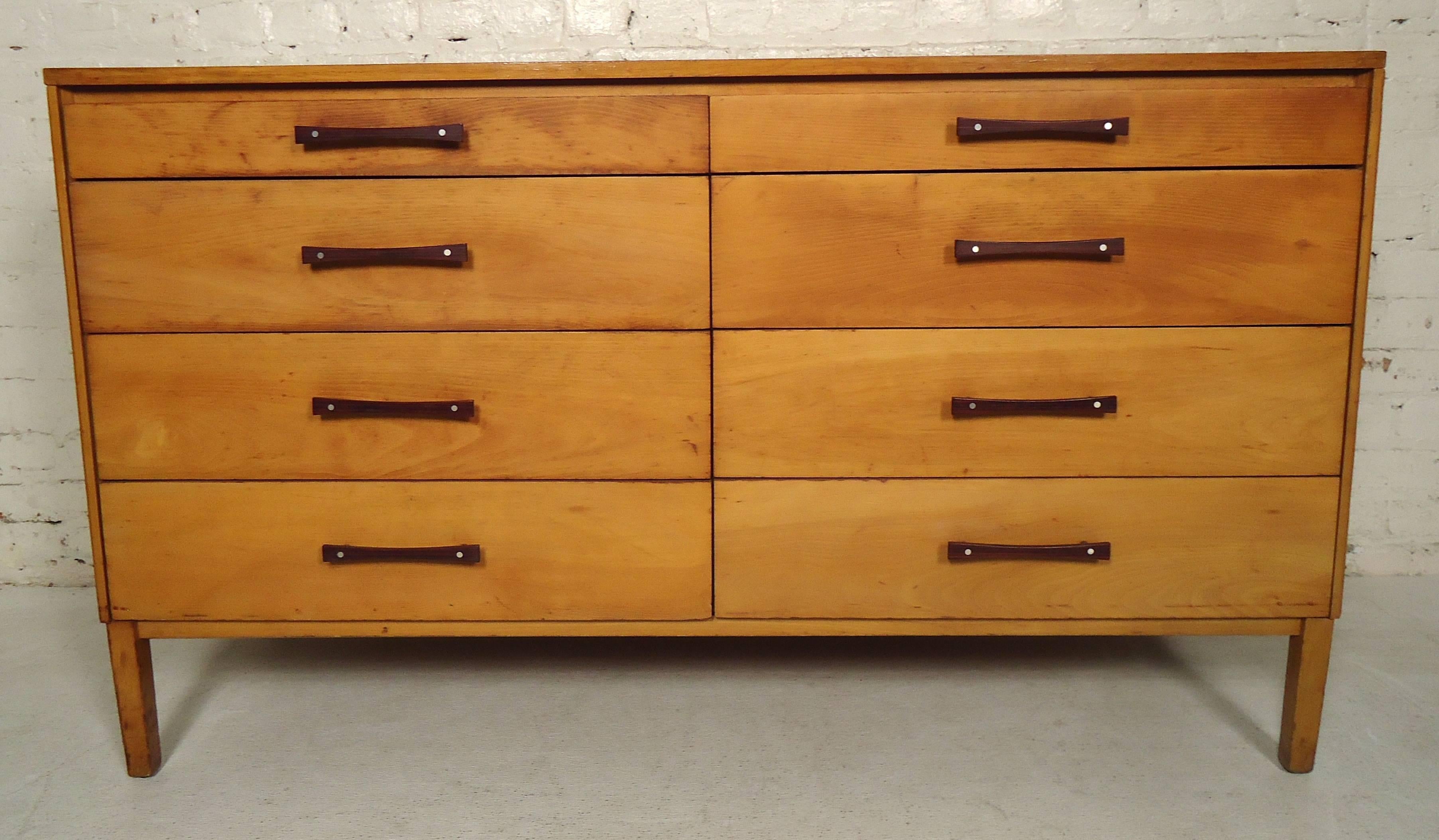 This vintage modern Paul McCobb eight-drawer dresser features graduated drawers with bowtie shaped rosewood and aluminium pulls. The Perimeter Group is a very hard to find and rare line which was manufactured by the Winchendon Furniture Company.