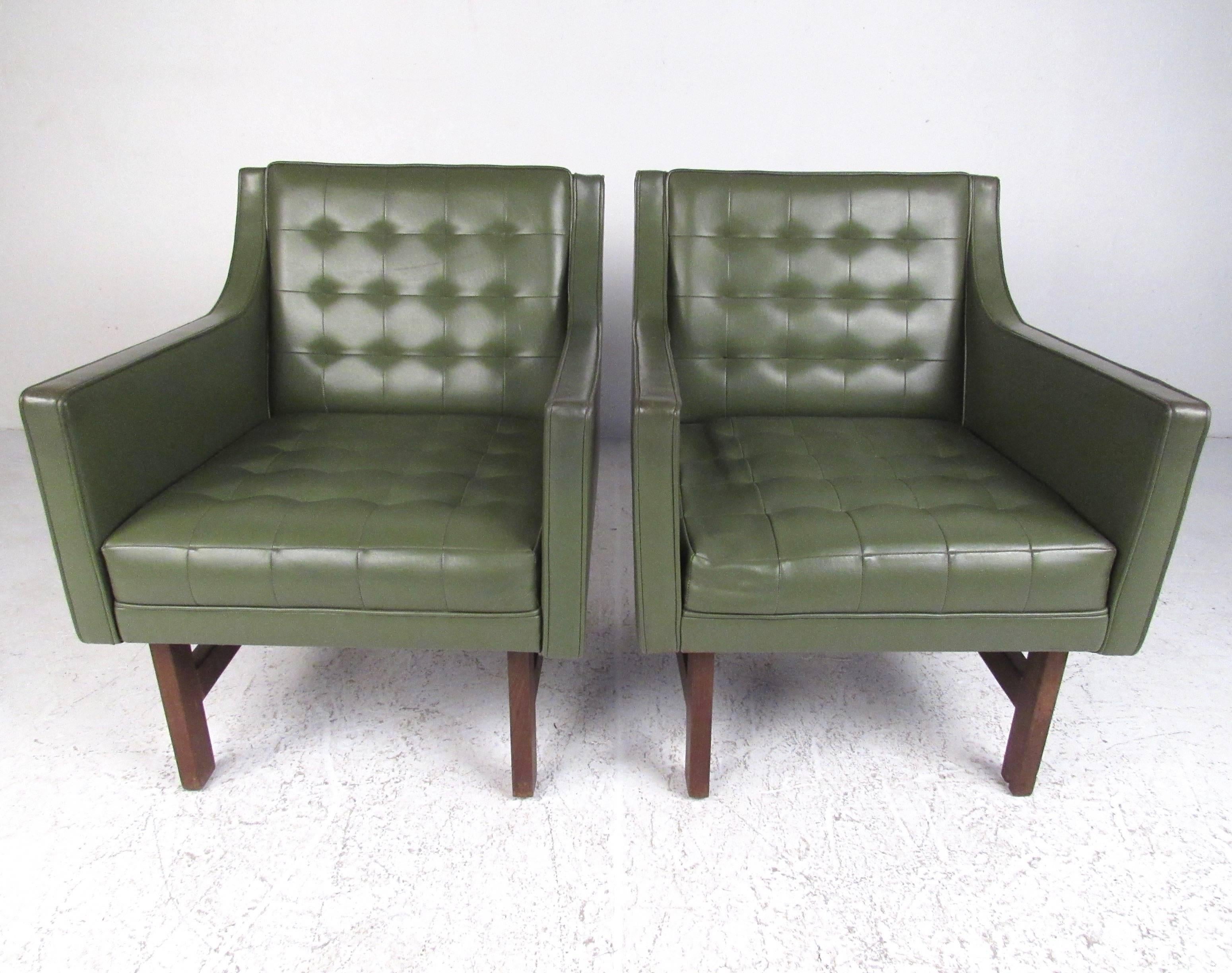 This pair of vintage vinyl club chairs feature stylish sloped armrests, tufted seat backs, and teak frames. Mid-Century Modern design makes these a memorable addition to any interior, unique seating for home or business. Please confirm item location
