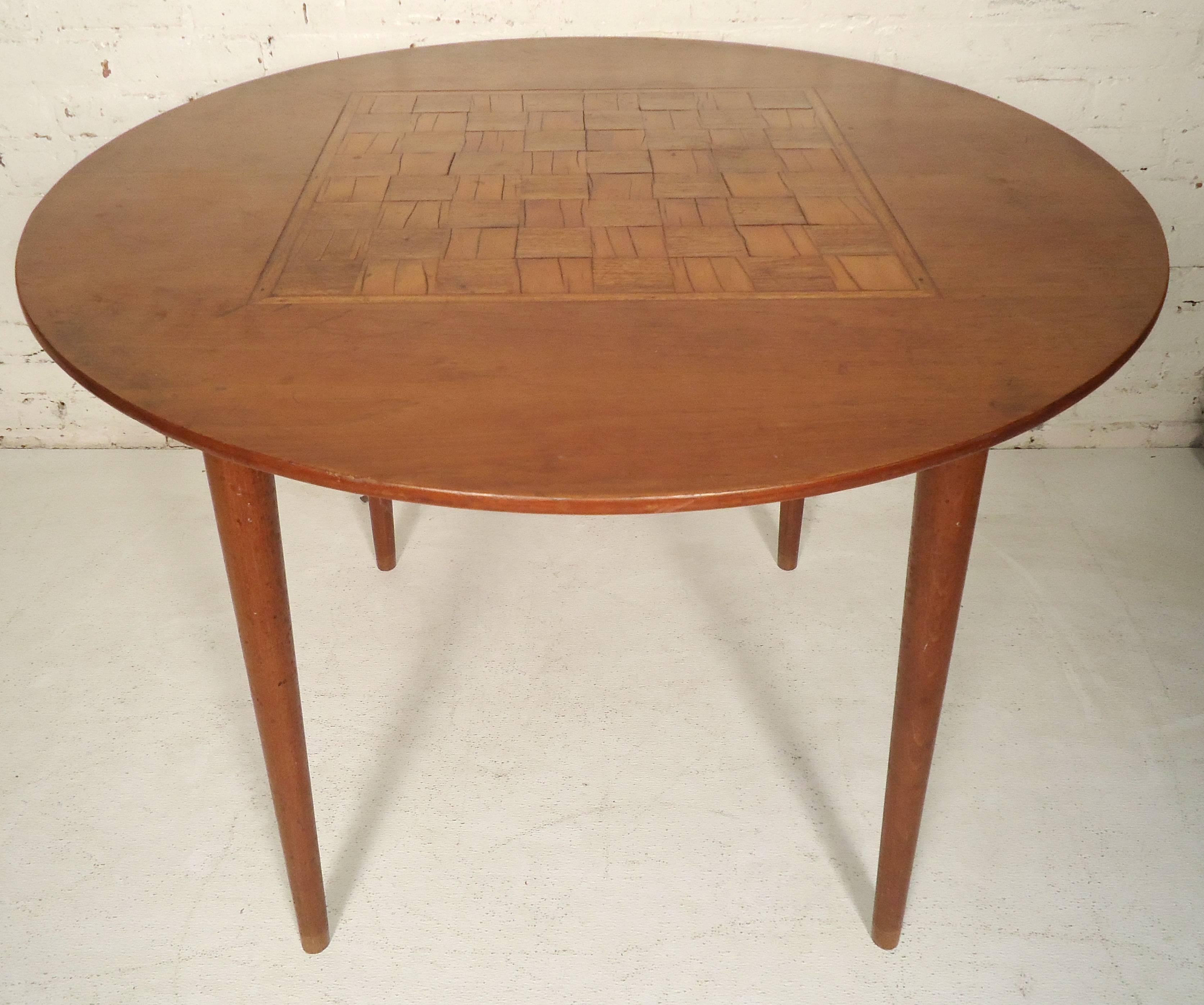 Round midcentury dining table with 64 square wood inlays. Long tapered legs, great for a kitchen nook.

(Please confirm item location - NY or NJ - with dealer).
     