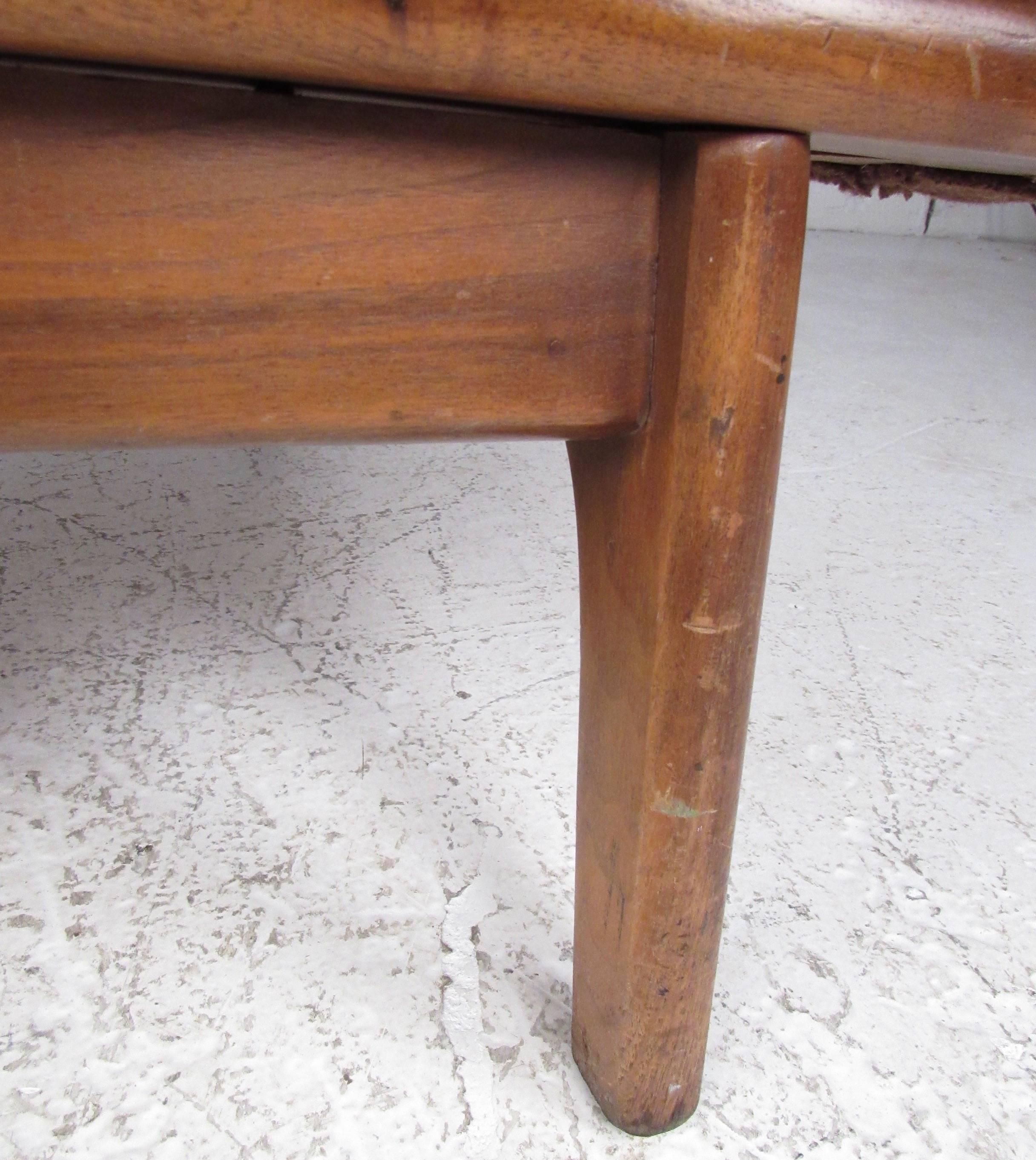 This unique three-seat sofa features tapered hardwood legs and sculpted wooden armrest details. Vintage brown fabric adds to the Mid-Century Modern feel of this Adrian Pearsall style sofa. Please confirm item location (NY or NJ).