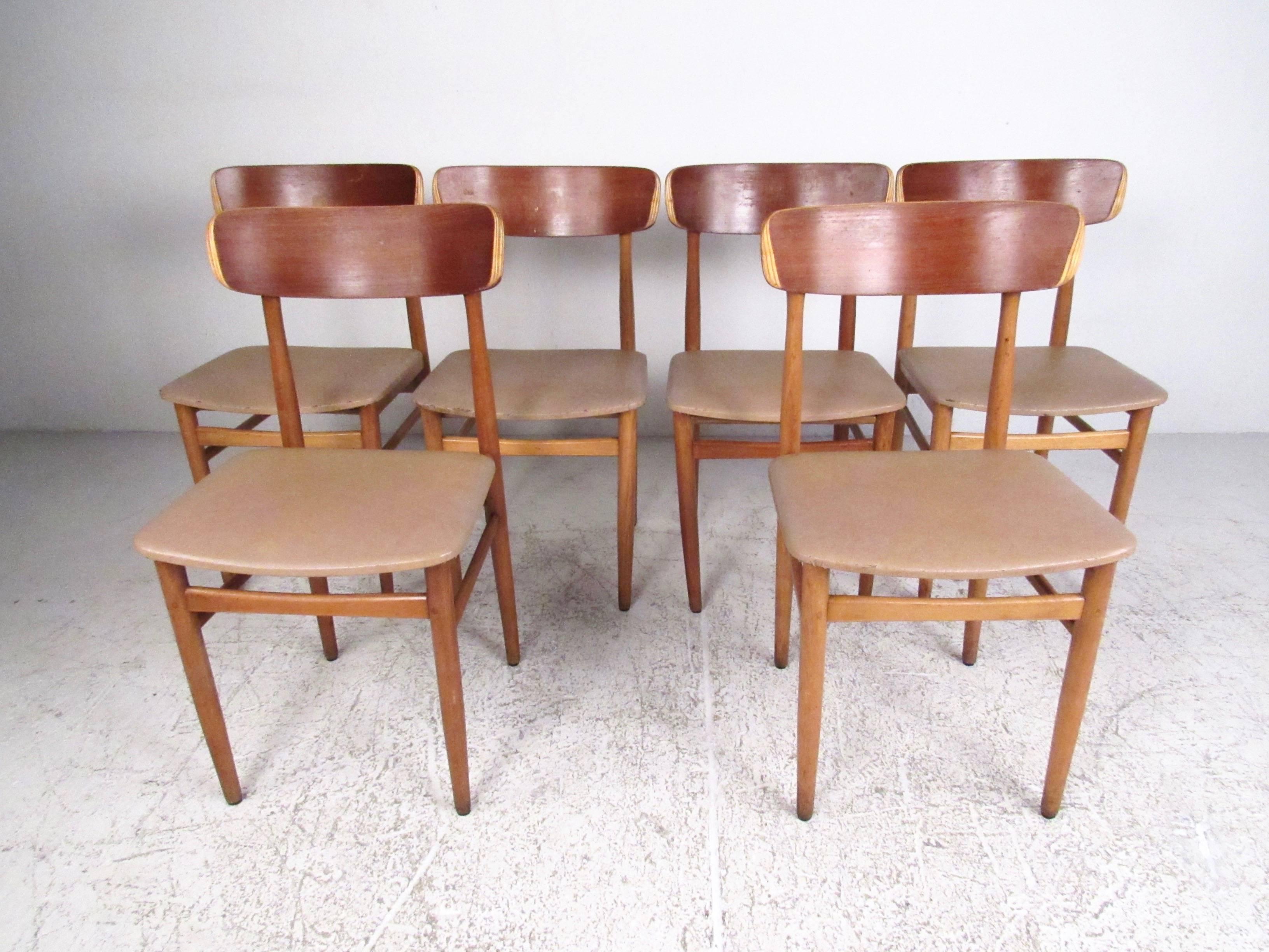 This stylish set of Scandinavian style dining chairs features vinyl seats, hardwood frames, and clean modern design. Simple yet comfortable midcentury chairs make a unique addition to home or business. Please confirm item location (NY or NJ).