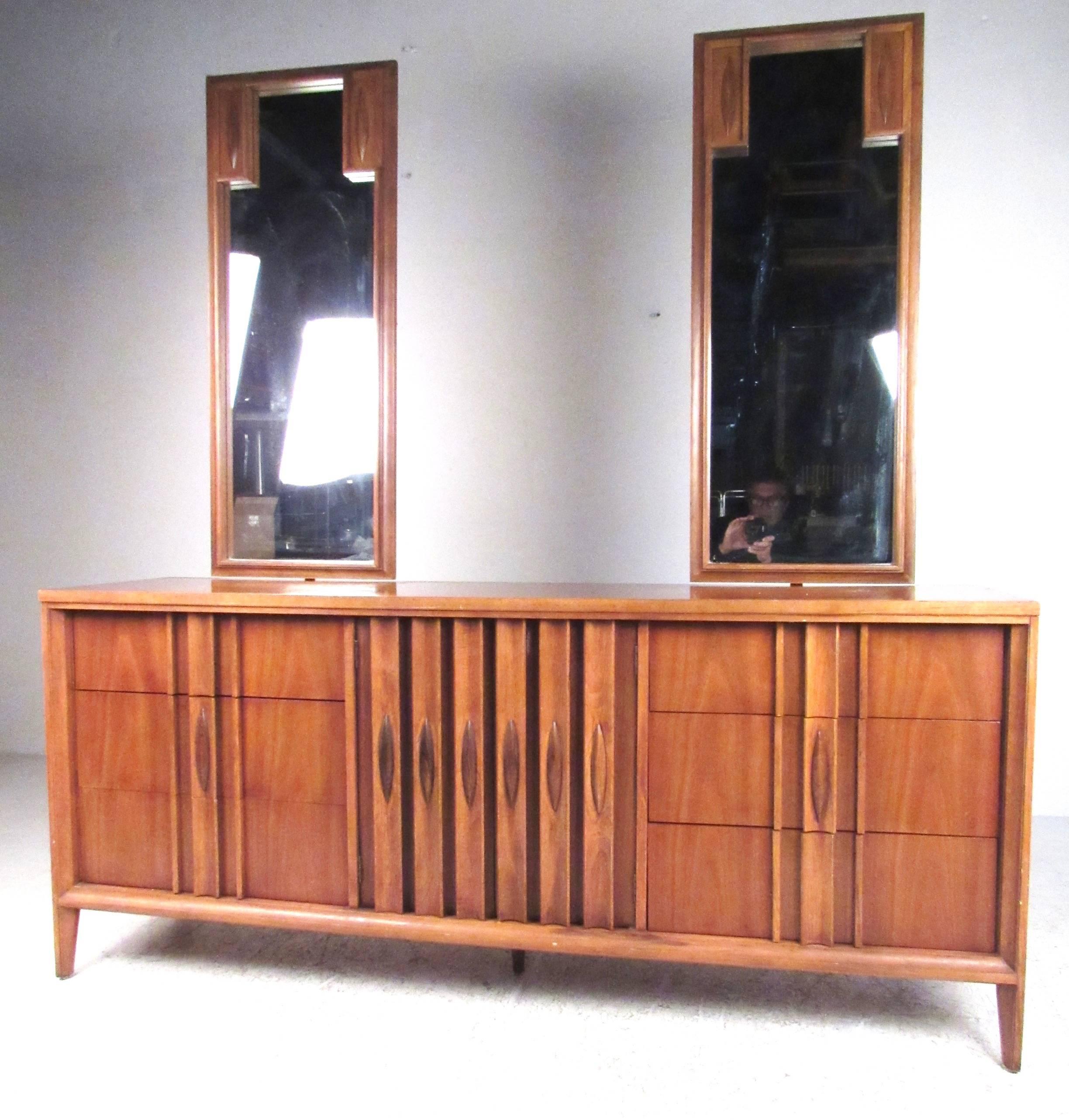This beautiful six piece bedroom set features sculpted American modern design with unique handles. Matching suite offers plenty of storage space with highboy and lowboy, pair of nightstands, and two dressing mirrors. Unique midcentury design, please
