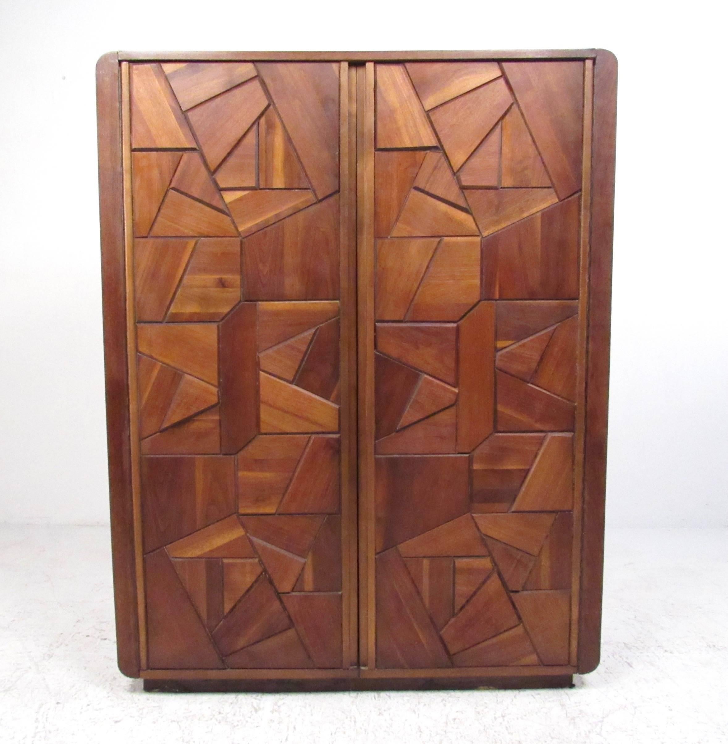 This stylish vintage modern armoire combines shelf storage with spacious drawers for plenty of bedroom storage. Mosaic like sculptural wood front cabinet doors add to the midcentury Brutalist appeal of the piece. Please confirm item location (NY or