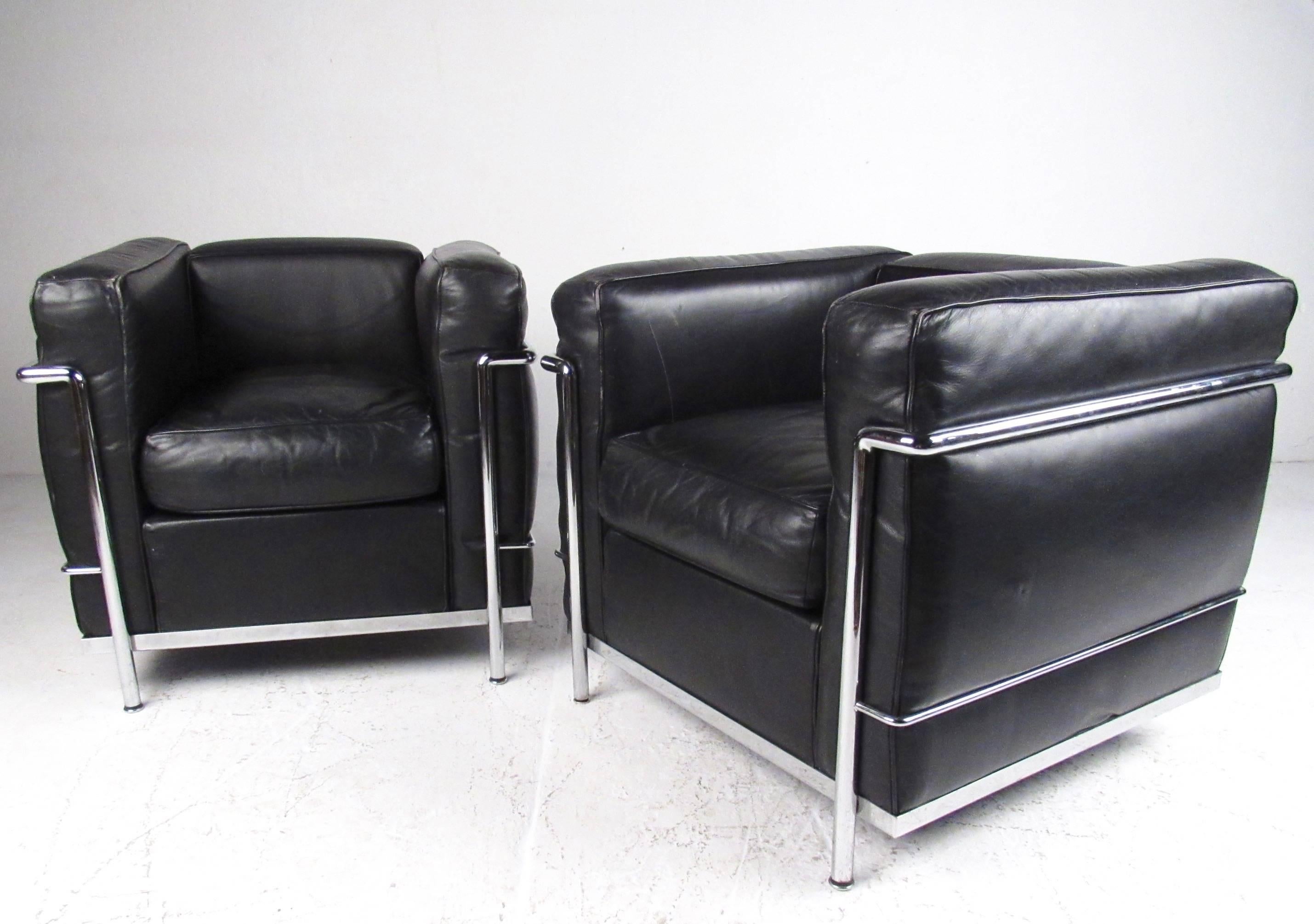 This iconic Le Corbusier LC set features iconic mid-century design by Italian manufacturer Cassina. Three piece matching set features matched pair of LC2 club chairs with LC3 sofa, all with vintage leather upholstery and sturdy chrome frame. Perfect