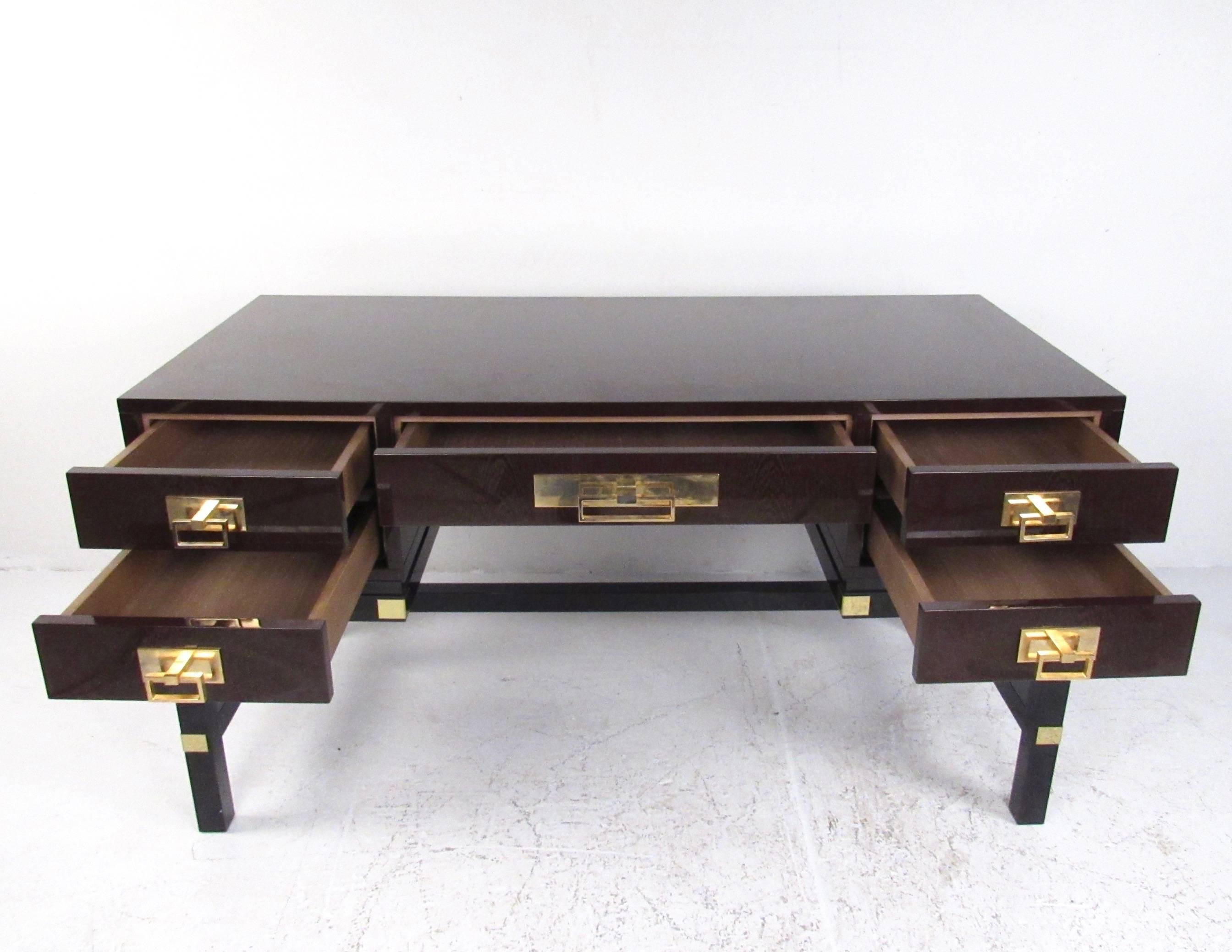 This stunning lacquered mahogany desk features classic campaign style design with spacious drawers and eye-catching brass trim. Sturdy and impressive executive desk features finished back and quality construction, perfect for home or business