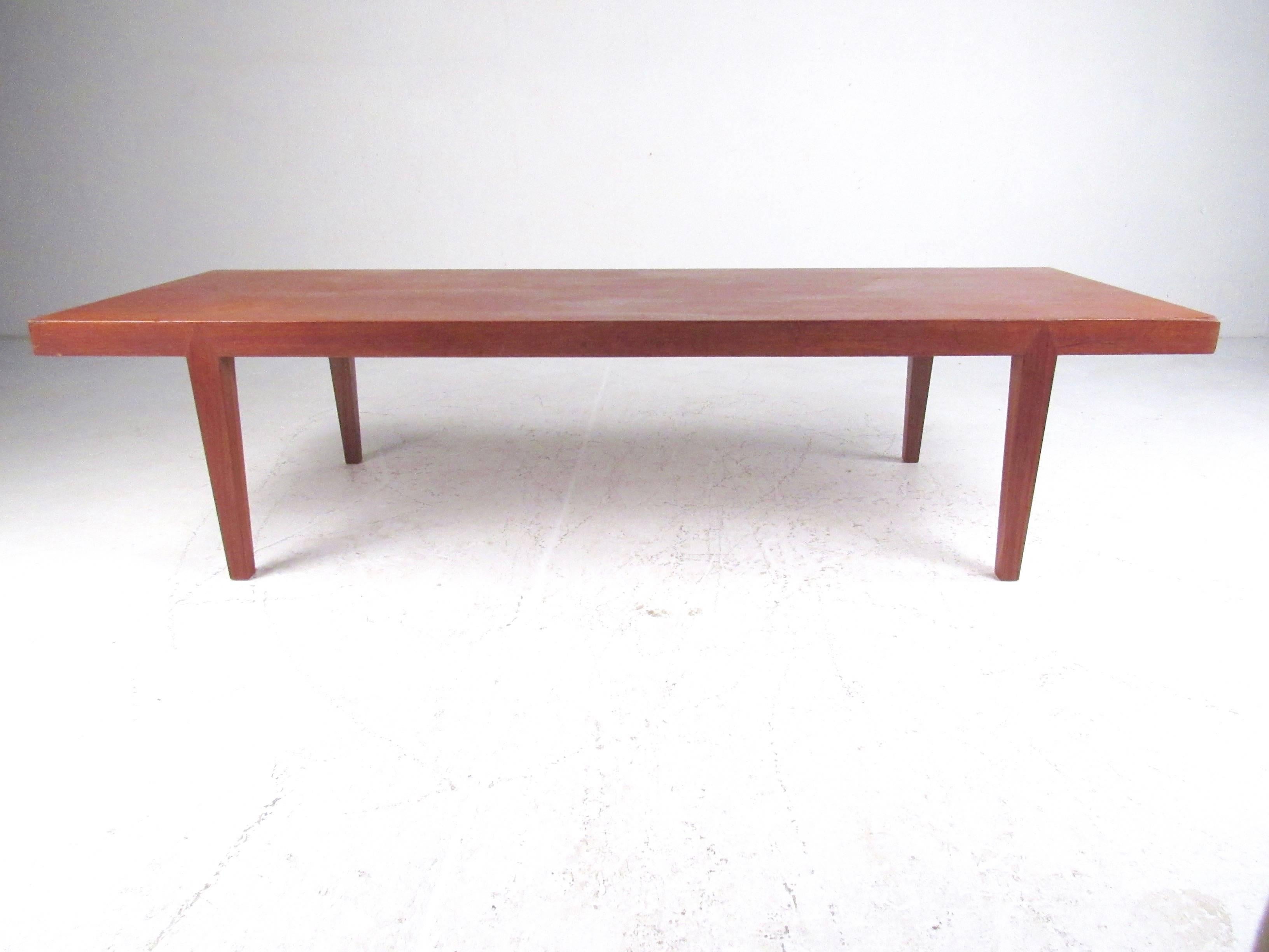 This simple yet stylish vintage teak coffee table features Danish modern design, tapered legs, and rich natural finish. Danish markers mark on the bottom of the table, please confirm item location (NY or NJ).