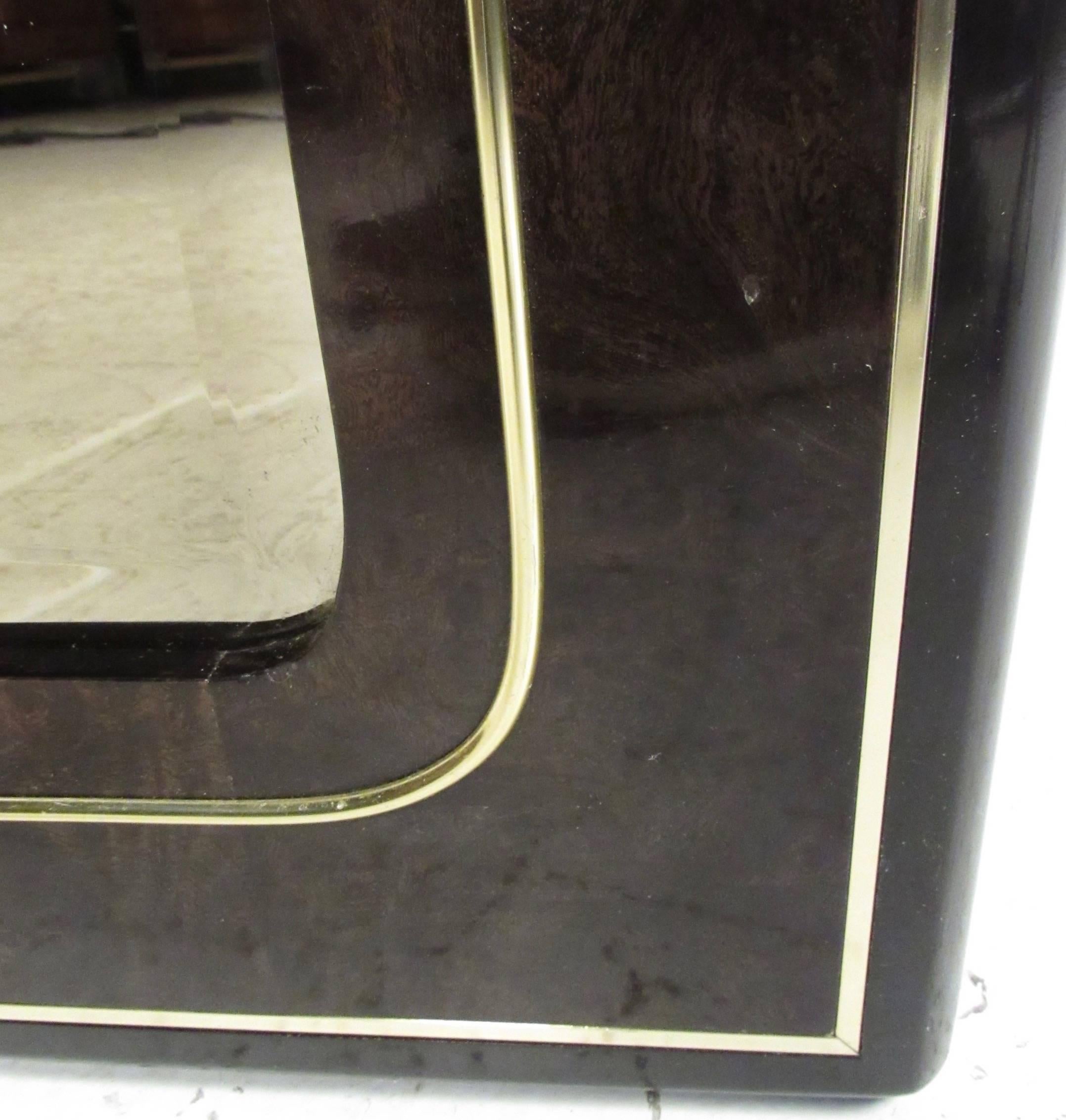 This unique lacquered burl wood mirror features brass trim, and acid-etched brass detail. This large Bernhard Rohne mirror makes this vintage modern midcentury mirror a stylish and impressive addition to any interior. Please confirm item location