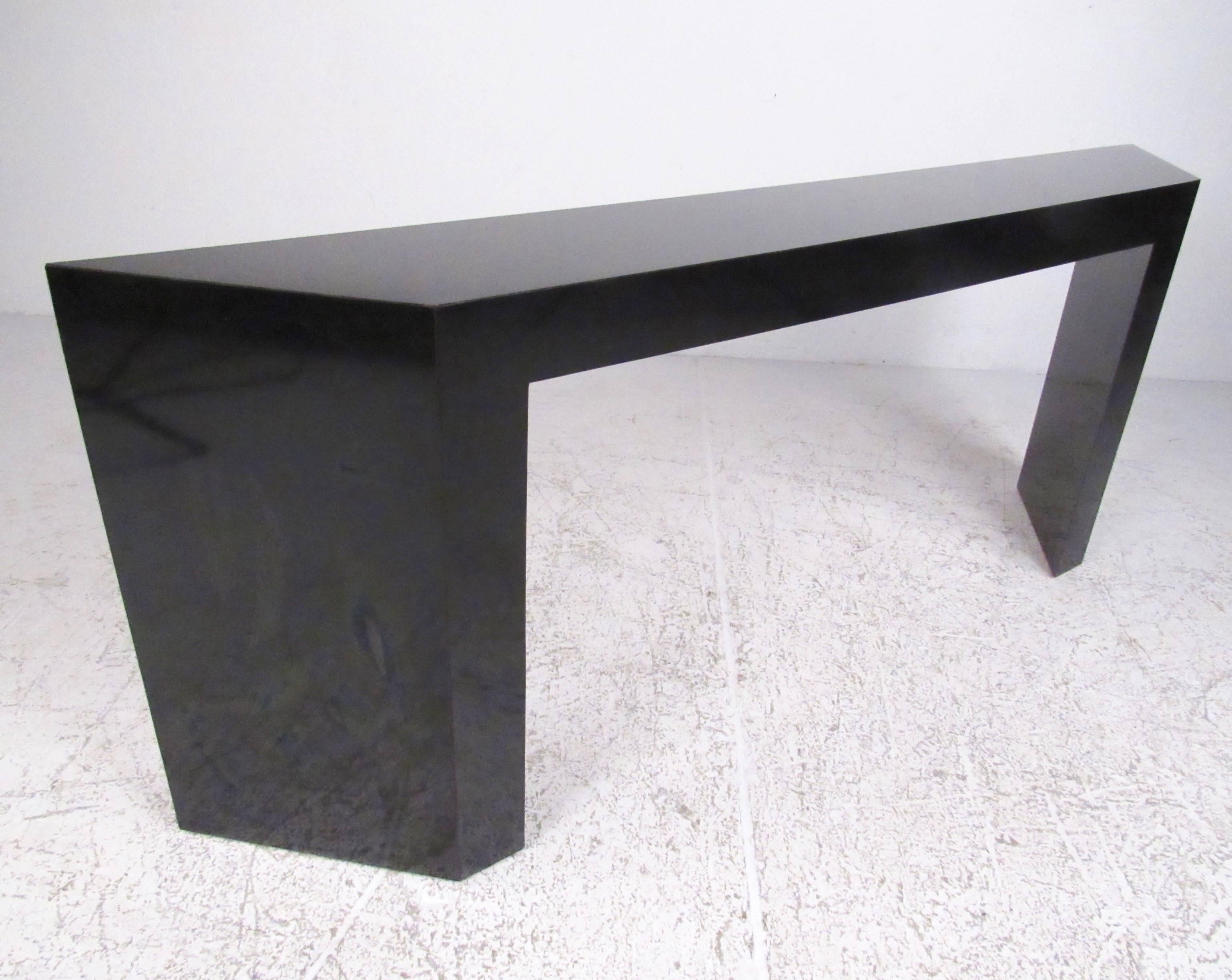 This modern sculpted console table features black formica finish and unique sculpted details. Perfect table for entryway display, office storage, or for use as a sofa table. Please confirm item location (NY or NJ).