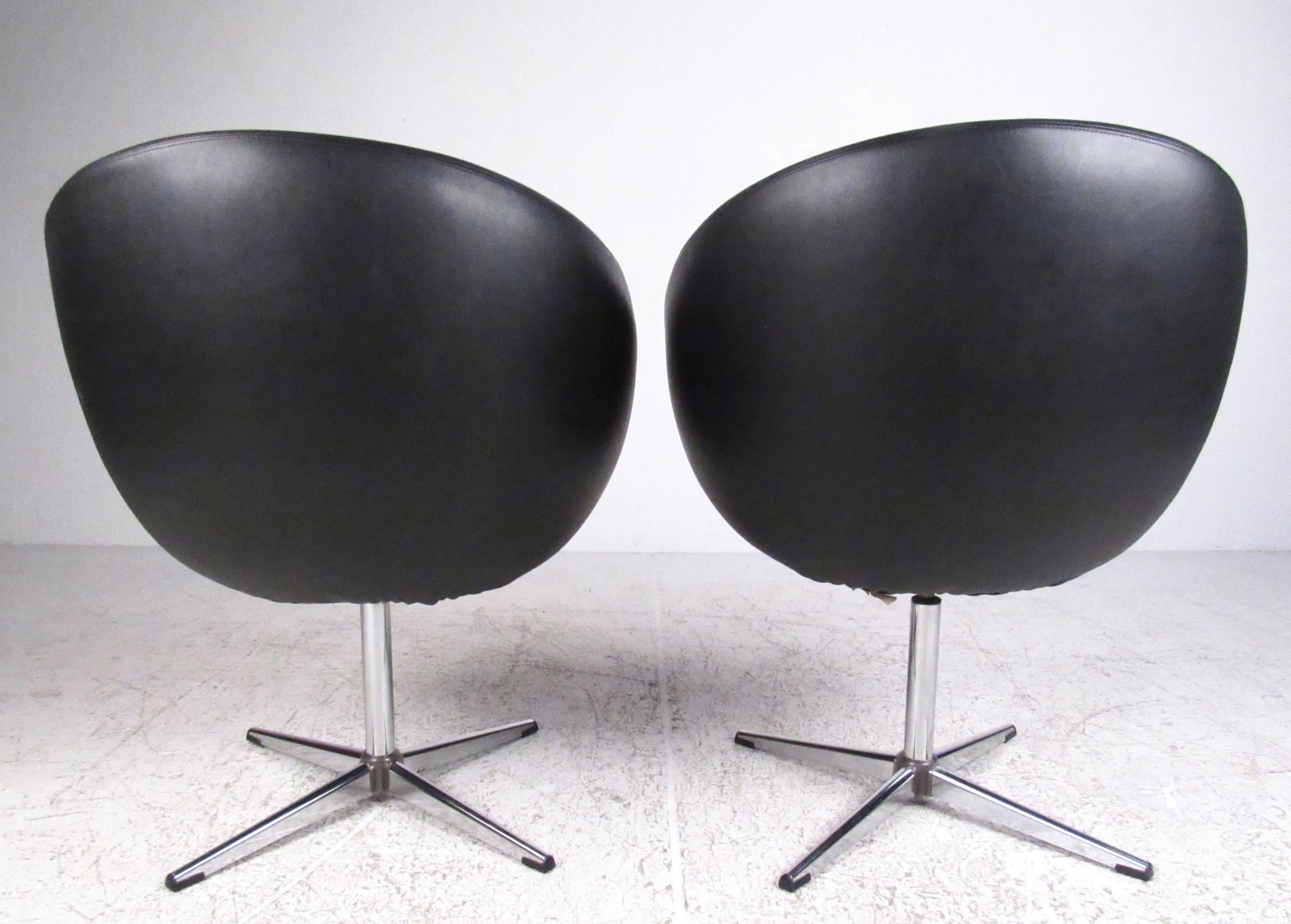 Cette paire emblématique de chaises overman pod se caractérise par des sièges pivotants sur une base robuste en 