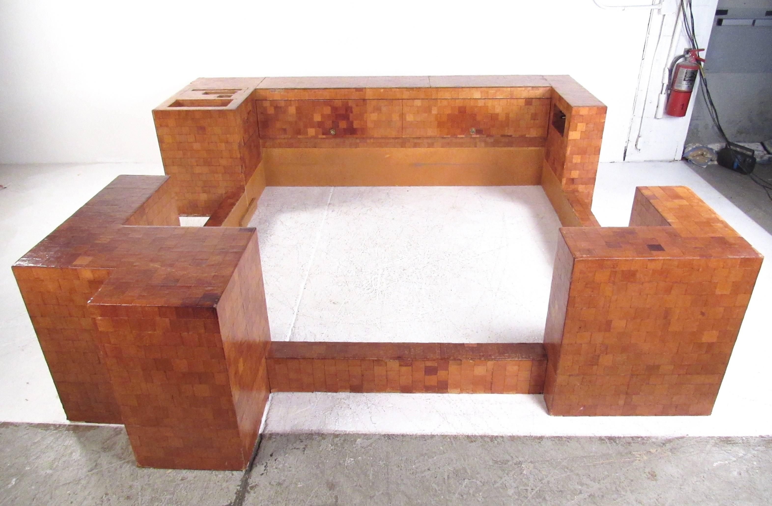 This large scale king-size bed frame features impressive custom design. Unique storage space in frame through various cubbys and cabinets, with original wiring awaiting your customizations. This multi-piece king size bed frame also features raisable