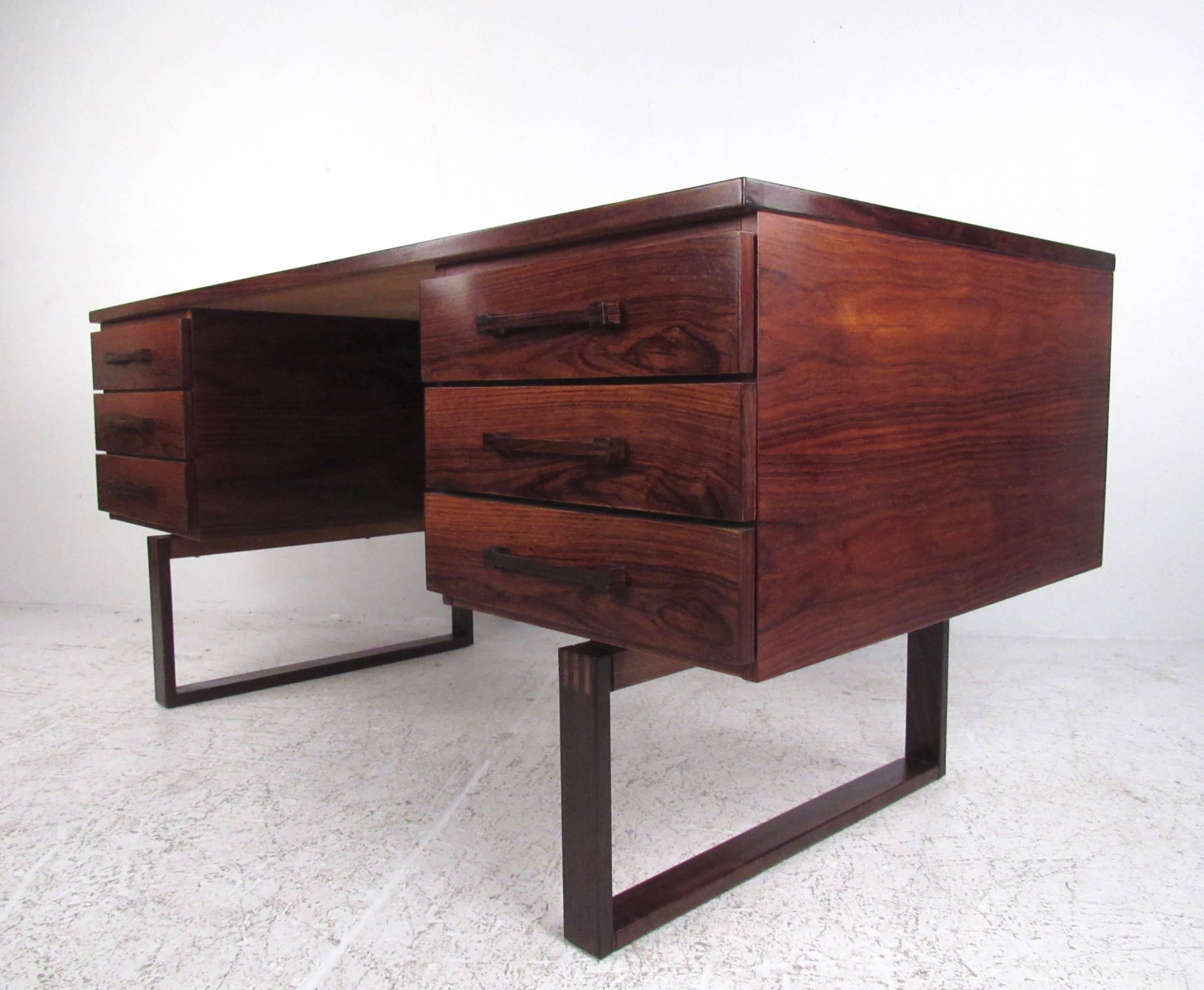 This stylish midcentury rosewood desk features exquisite wood choice, sled legs, open compartment shelf back, and dovetail detail joints. This impressive large-scale executive desk is perfect for home or business office. Please confirm item location