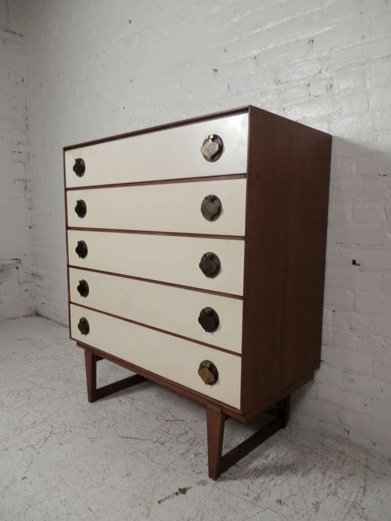 Mid-century modern furniture by Stanley featuring white front drawers accenting the deep walnut wood body. Spacious drawers with over-sized brass spade shaped hardware that add a whimsical style. A unique find.
Nightstand included.

(Please confirm