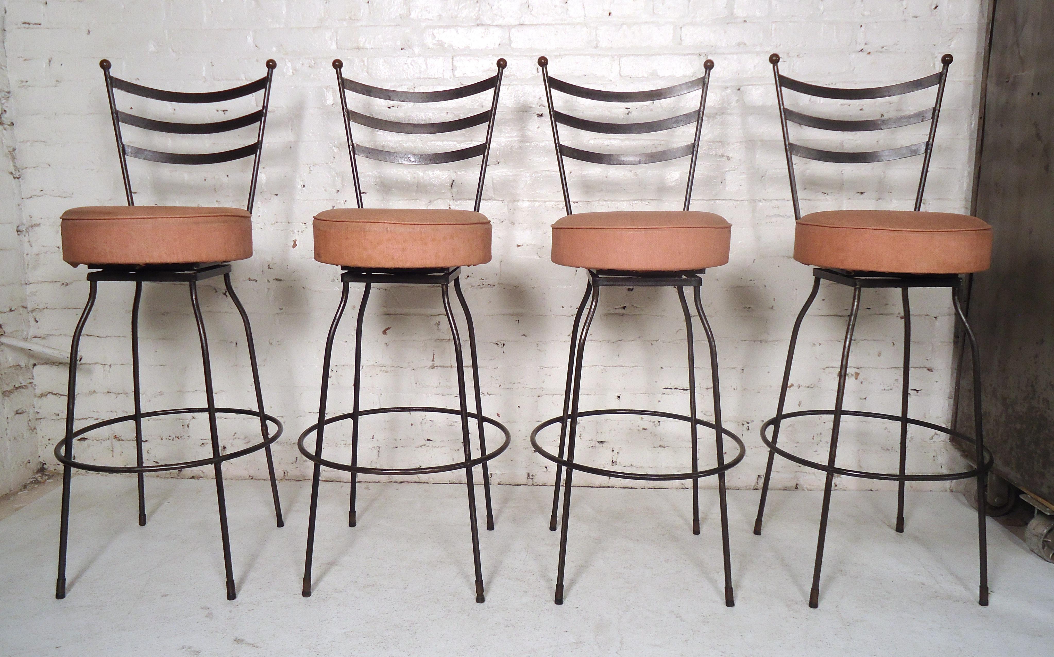 Set of Industrial stools featuring a slatted back, sturdy black iron legs and upholstered swivel seating.

(Please confirm item location - NY or NJ - with dealer).