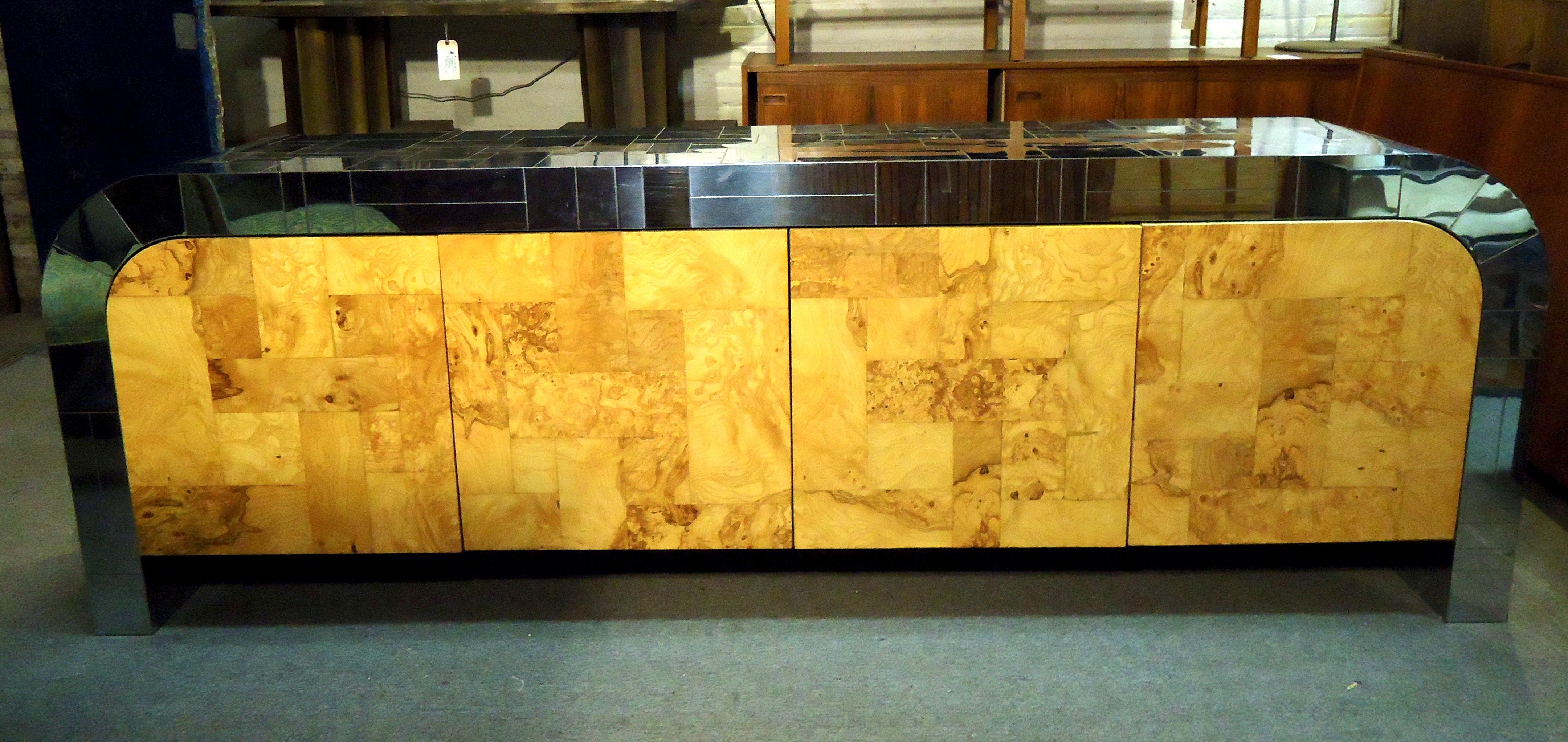 Gorgeous vintage modern Paul Evans credenza features spacious storage cabinets, three drawers, chrome top and sides, and burl wood doors. Signature is located on the inside foot underneath the cabinet.

(Please confirm item location - NY or NJ -