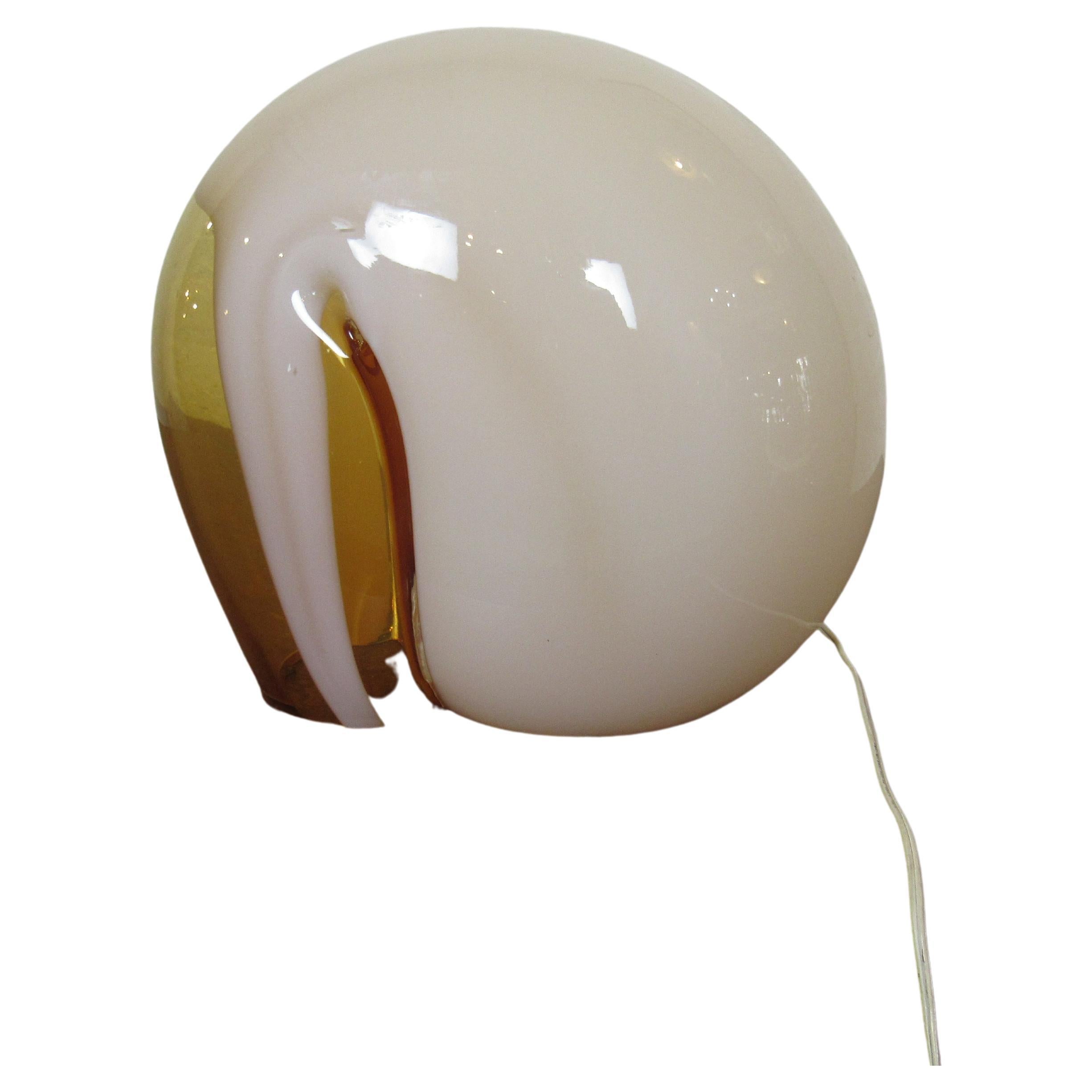 With swirls of opaque color mixing through translucent orange glass, this blown glass table lamp provides warm soft lighting in a unique form. Please confirm item location with seller (NY/NJ).