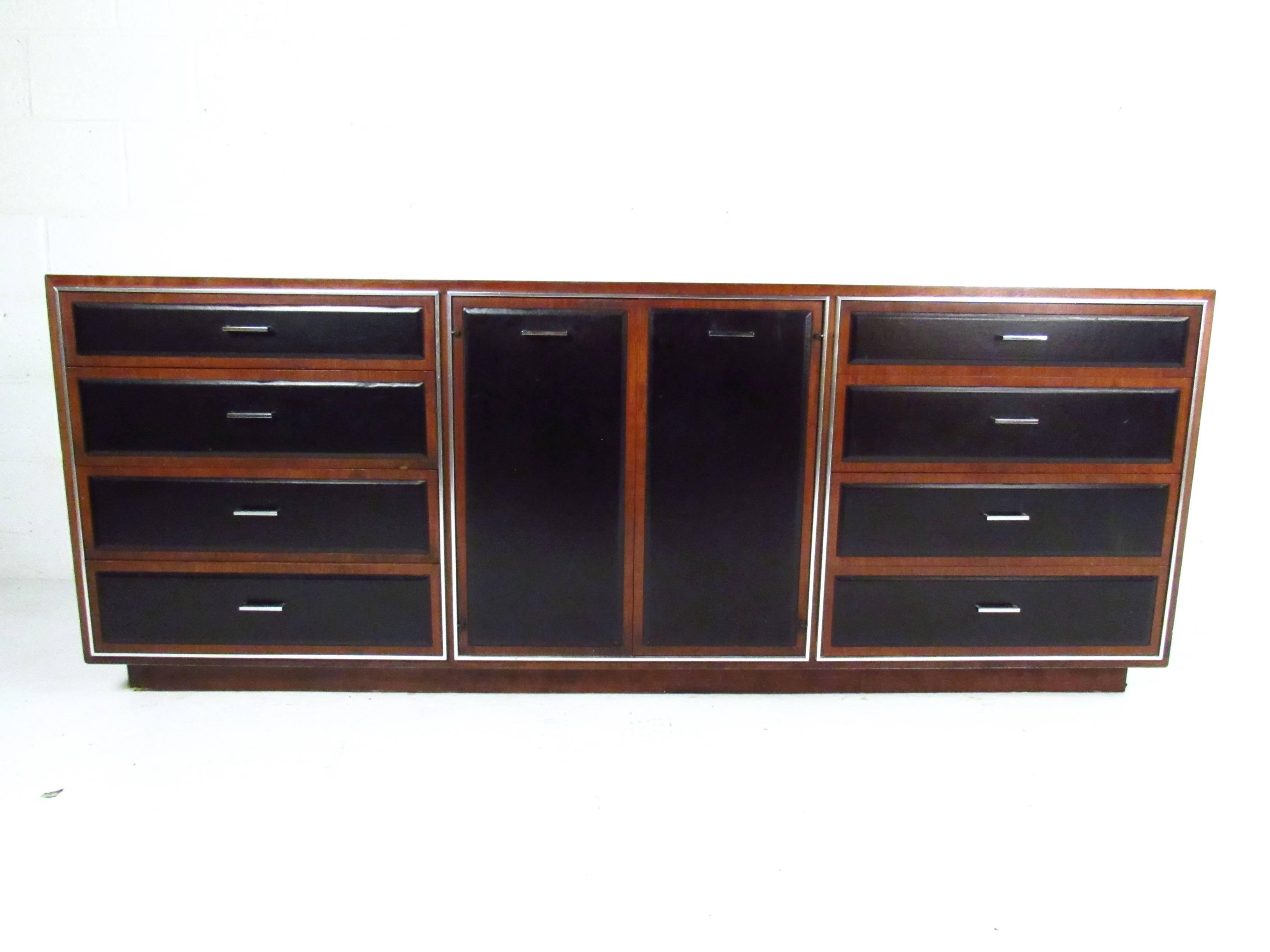 This beautiful server features exquisite leatherette paneled drawer fronts, chrome trim and pulls, and makes a stylish addition to any interior. This unique vintage design offers plenty of space for bedroom storage, and has a matching armoire and