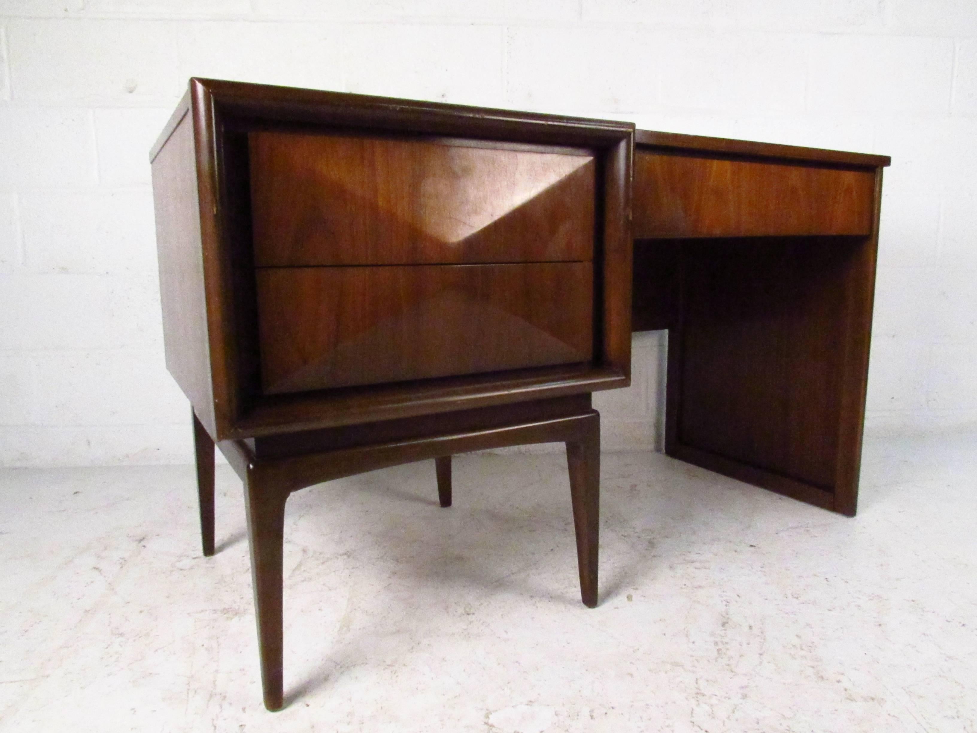 This beautiful Mid-Century walnut desk features a unique sculpted front, tapered legs, and three drawers for workspace storage. Fantastic vintage style in a compact yet practical design, please confirm item location (NY or NJ). Matching end tables