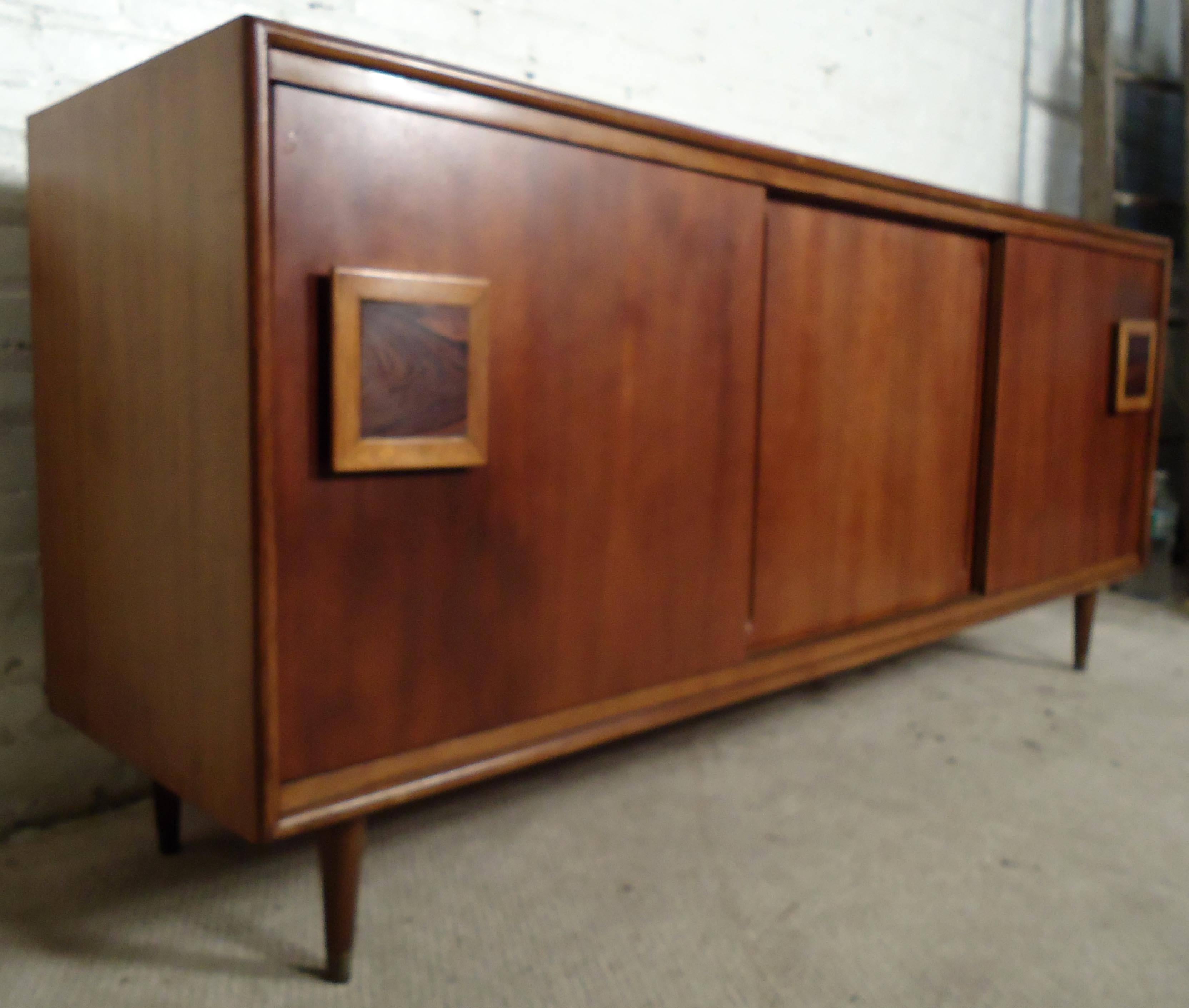 Vintage-modern server, features walnut top, teak front, and sculpted rosewood handles with oak accenting. Sliding doors reveal both drawers and adjustable shelving.

Please confirm item location NY or NJ with dealer.