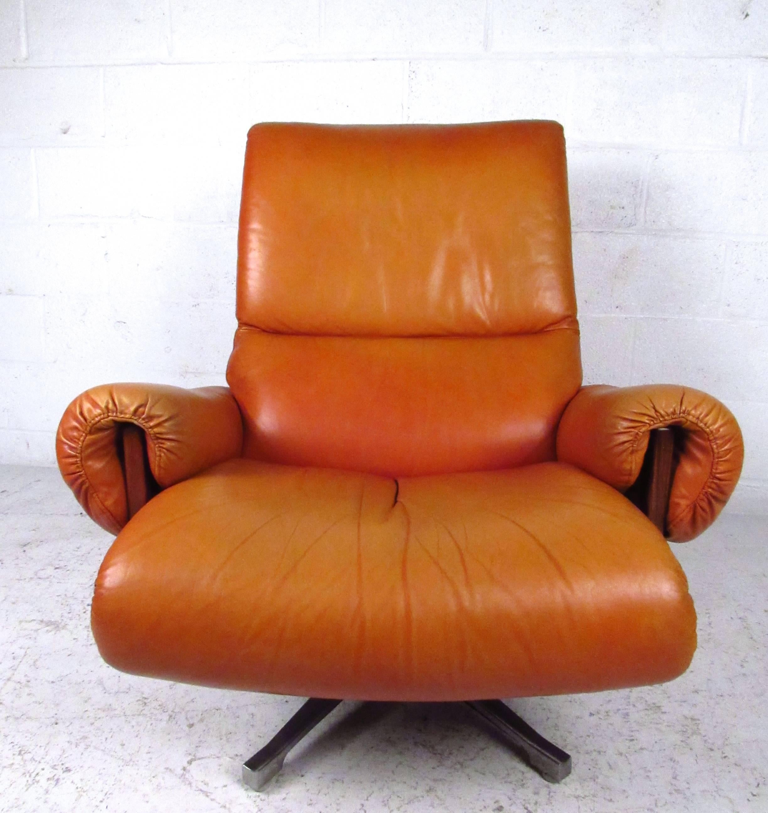 This unique and stylish pair of Scandinavian modern swivel chairs features comfortable leather upholstery, ample padding on arm rests and seat back, and a low profile swivel that adds even more comfort to the set. Rosewood frames show quality