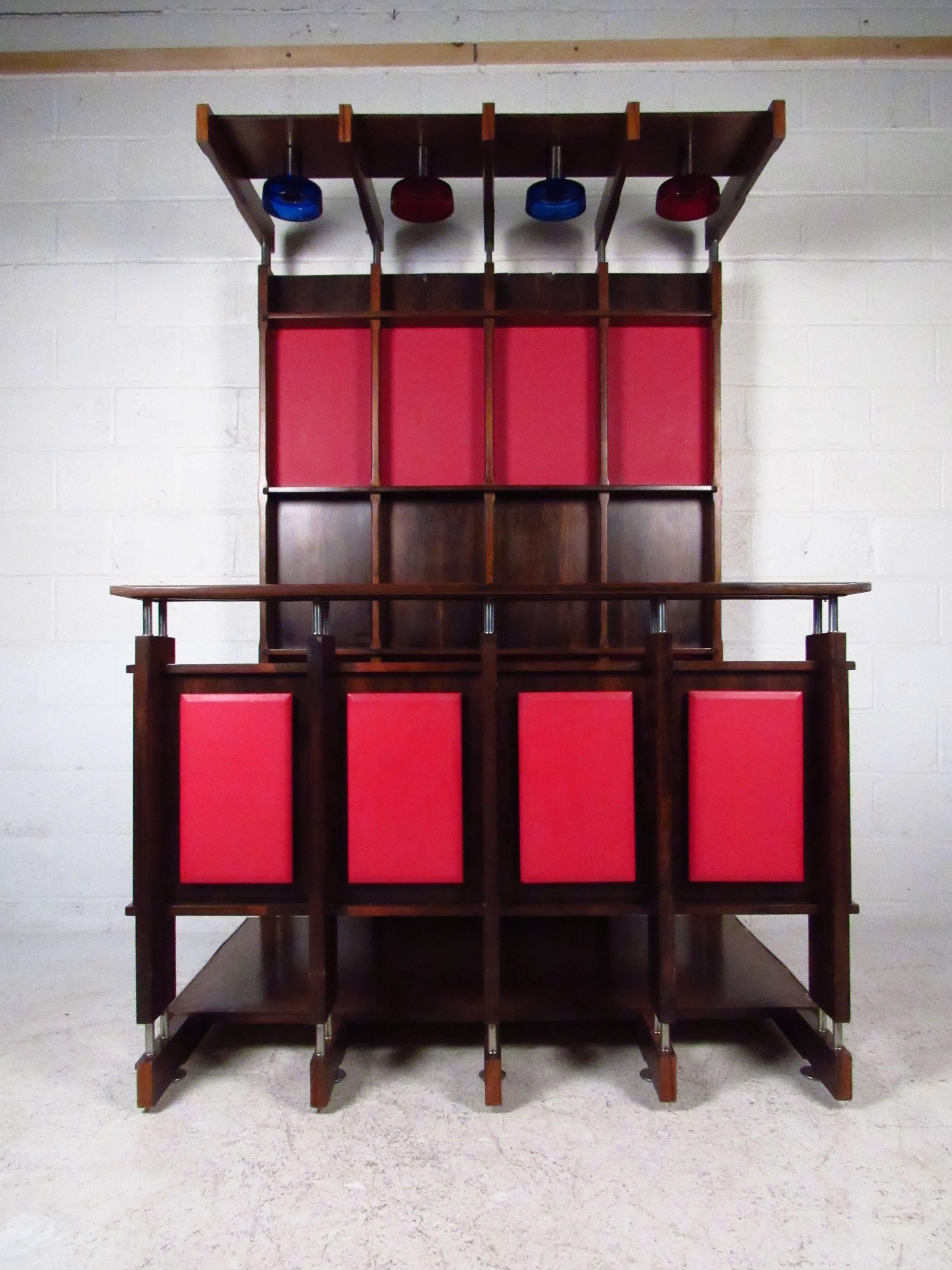 This gorgeous modular bar unit offers a beautiful mix of rosewood and colored paneling, with unique metal accents, and fantastic overhead lighting. Truly impressive piece makes a wonderful addition to any interior, and included floating bar top,