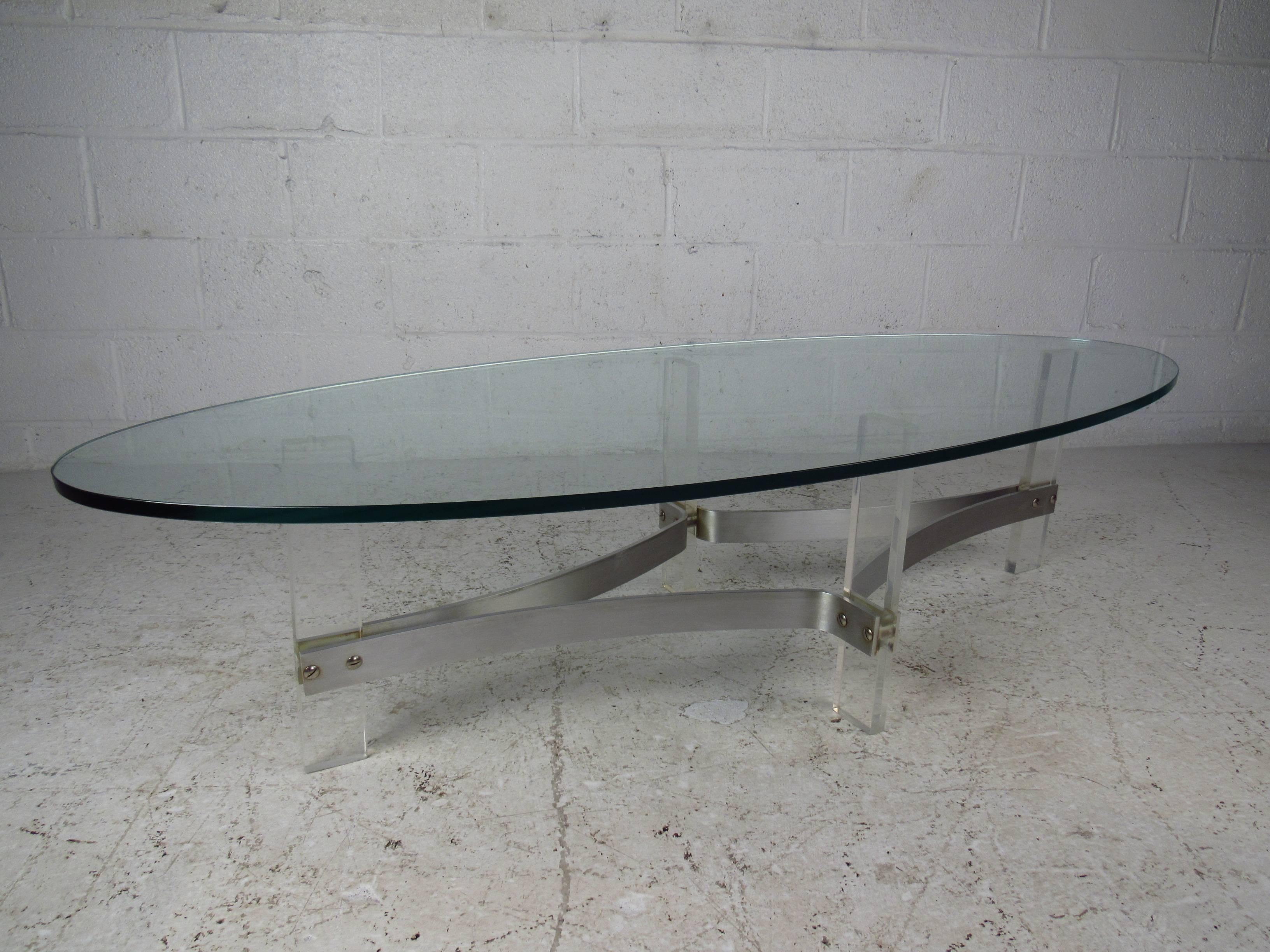This beautiful, oval Lucite coffee table features a unique curved base, providing not only stability but style. The sleek design of this piece compliments any setting. (Please confirm item location NY or NJ.)