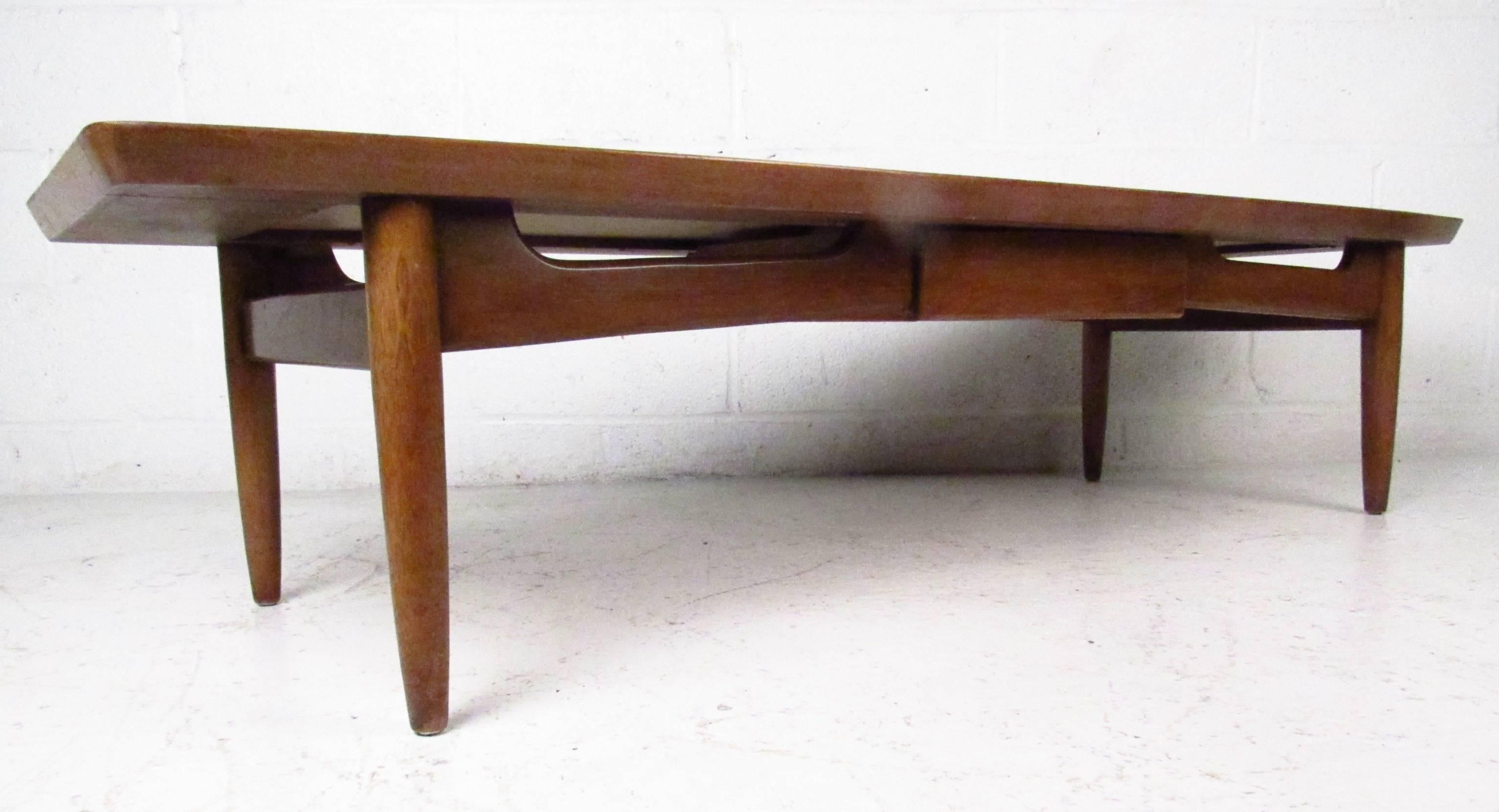 Long mid-century modern coffee table features walnut construction with laminate black top insert. Tapered legs and middle shelf add to the stylish vintage design and versatility of the piece.


(Please confirm item location - NY or NJ - with dealer)
