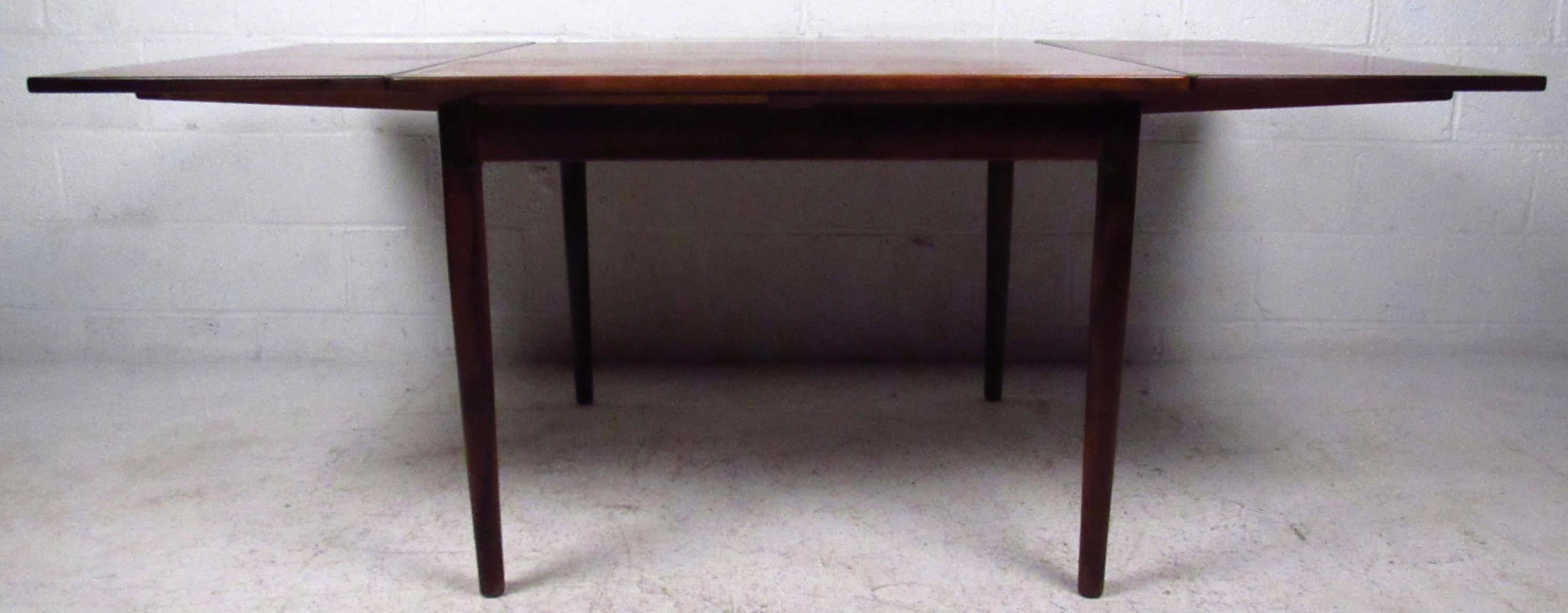 Vintage-modern dining table attributed to Arne Vodder, features two draw leaves and beautiful rosewood grain throughout. Danish modern draw-leaf dining table makes a striking mid-century addition to kitchen or dining room. 

Extended width - 75